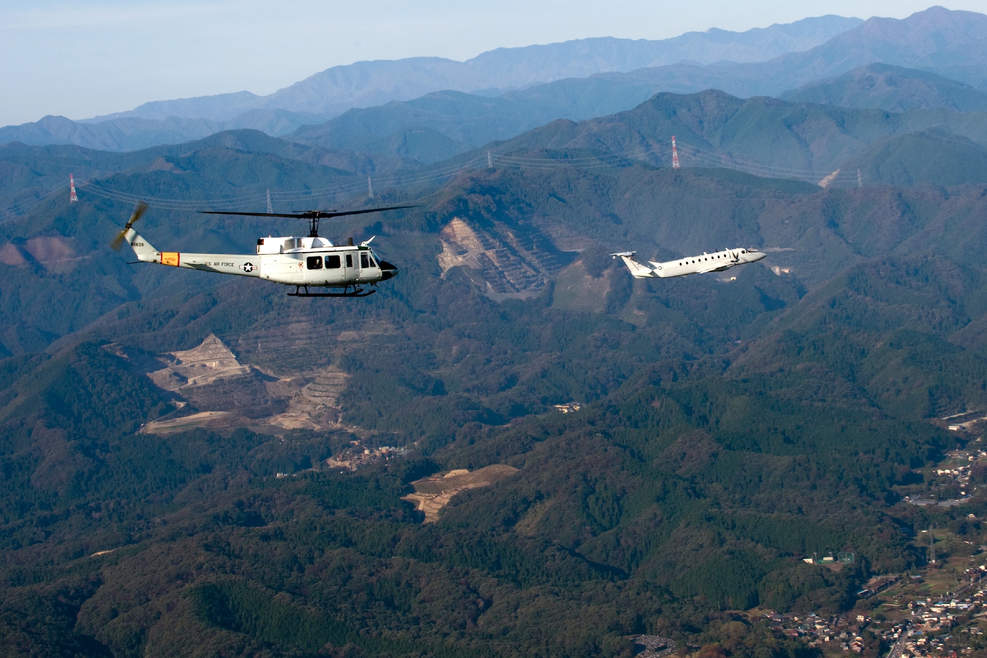 OVER JAPAN -- A UN-H1 Huey (left) and a C-12 Huron fly in the Kanto Plains region Nov. 2, 2011, at Yokota Air Base, Japan. The aircrafts flew in an exercise known as the Samurai Surge, a day dedicated to practicing aerial formations and other aircraft maneuvers. (U.S. Air Force photo/Airman John D. Partlow)