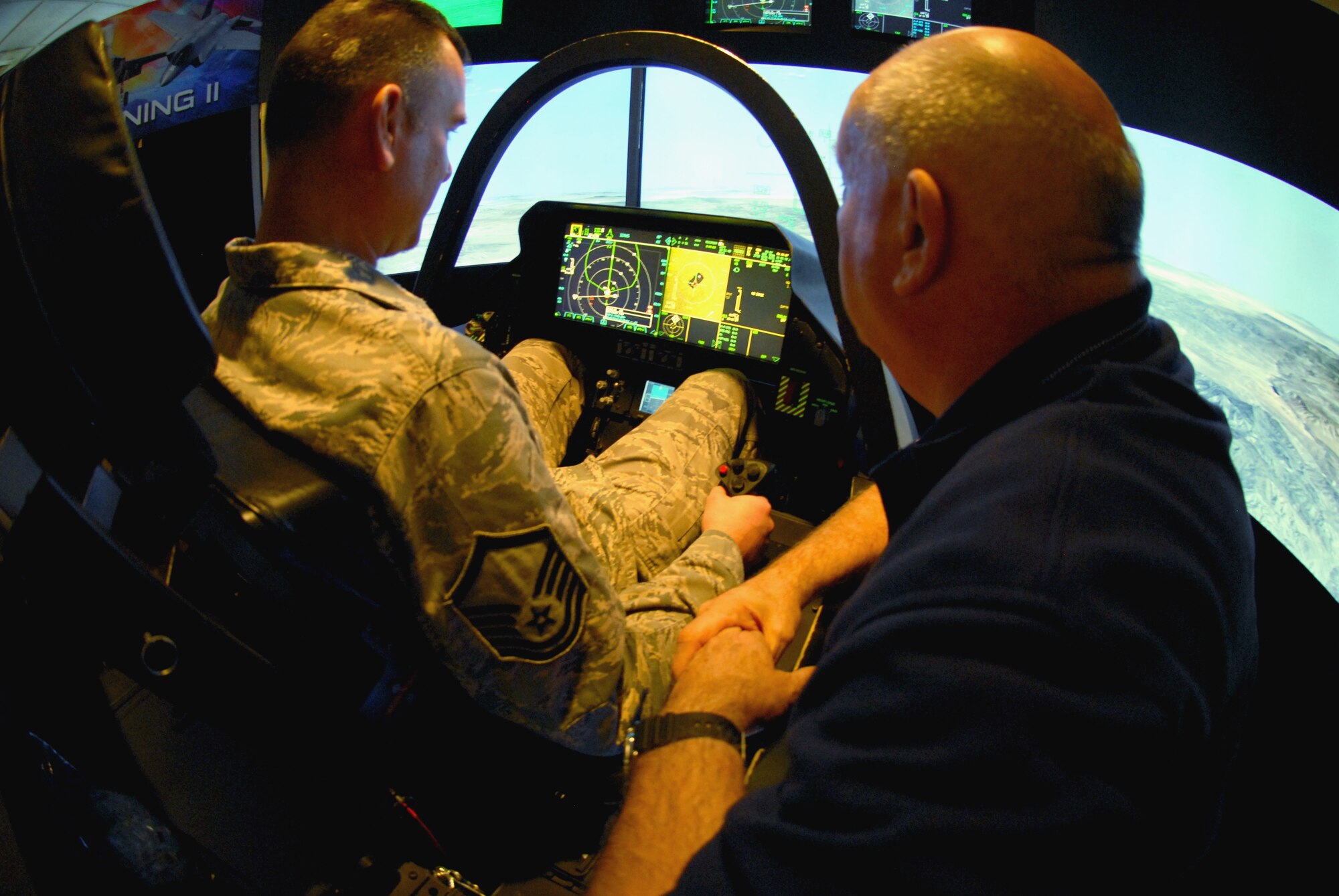 Stormy Boudreaux, an F-35 Lightning II instructor pilot with Lockheed Martin Aerodynamics, shows Master Sgt. Trevor Jackson, 8th Force Support Squadron dining facility section chief, how the new multi-role fighter will better serve the U.S. military at Kunsan Air Base, Republic of Korea, Nov. 1. The F-35 integrates advanced stealth technology into a highly agile, supersonic aircraft that provides the pilot with unprecedented situational awareness and unmatched lethality and survivability. (U.S. Air Force photo by Senior Airman Benjamin Stratton/Released)