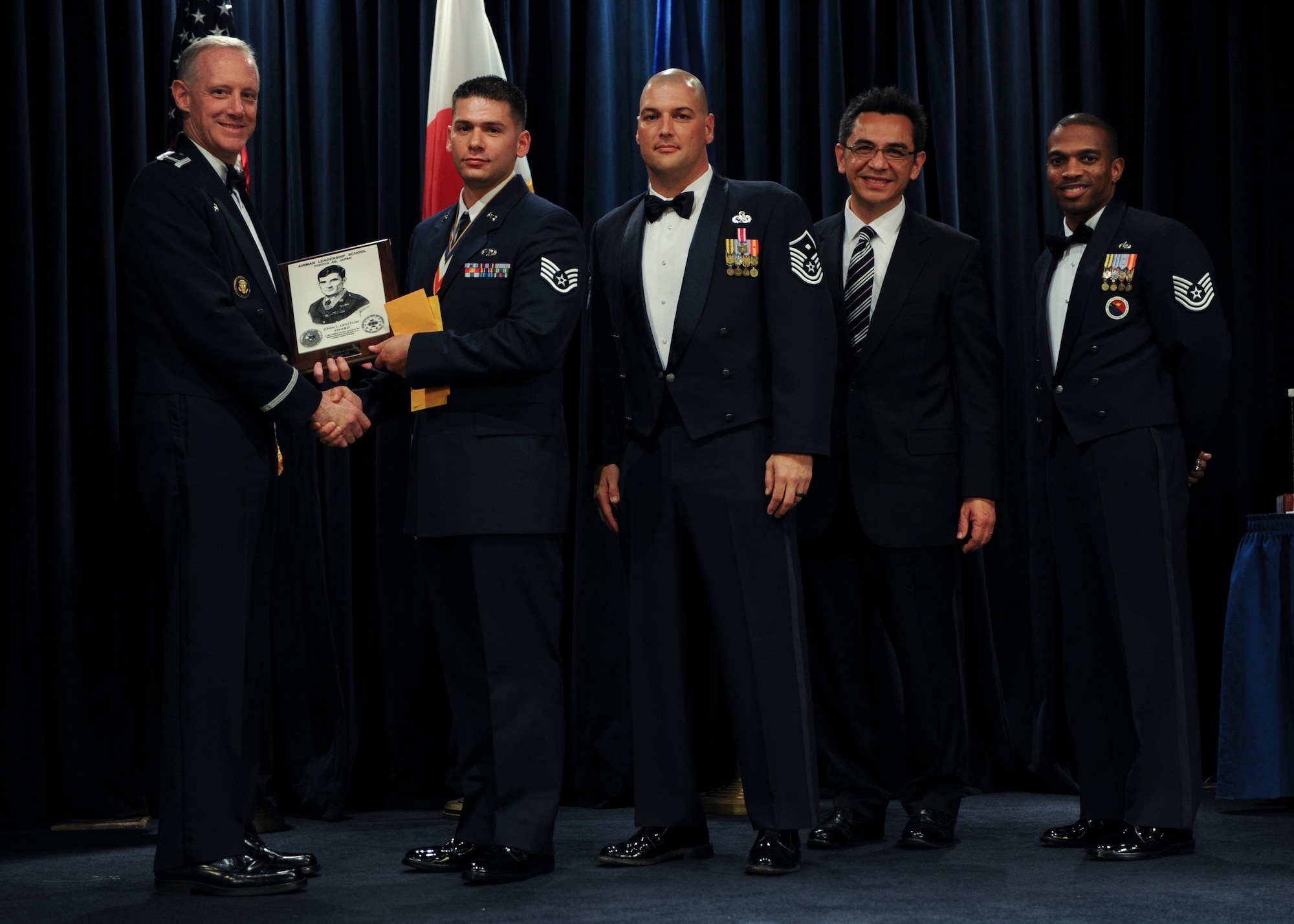 YOKOTA AIR BASE, Japan -- Colonel Otto Feather, 374th Airlift Wing commander, presents Staff Sgt. Joseph Muscarella, 374th Maintenance Squadron, the John L. Levitow Award, during the Airman Leadership School graduation ceremony at Yokota Air Base, Japan, Nov. 2. (U.S. Air Force Photo/Staff Sgt. Stacy Moless)