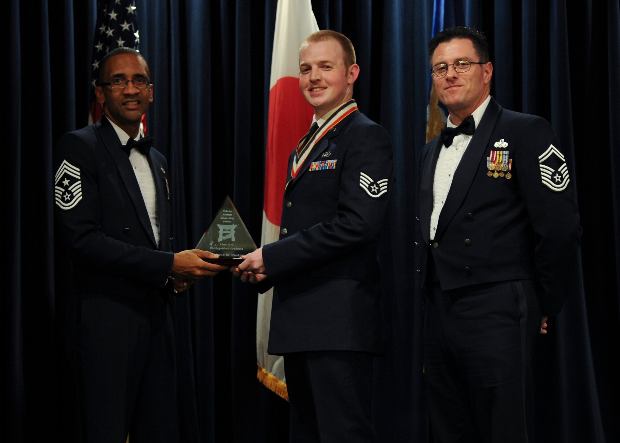 YOKOTA AIR BASE, Japan -- Staff Sgt. Jared Rustman, 5th Air Force, received the Distinguished Graduate Award, from Chief Master Sgt. Ron Draper, 374th Airlift Wing command chief, during the Airman Leadership School graduation ceremony at Yokota Air Base, Japan, Nov. 2, 2011. (U.S. Air Force photo/Staff Sgt. Stacy Moless)