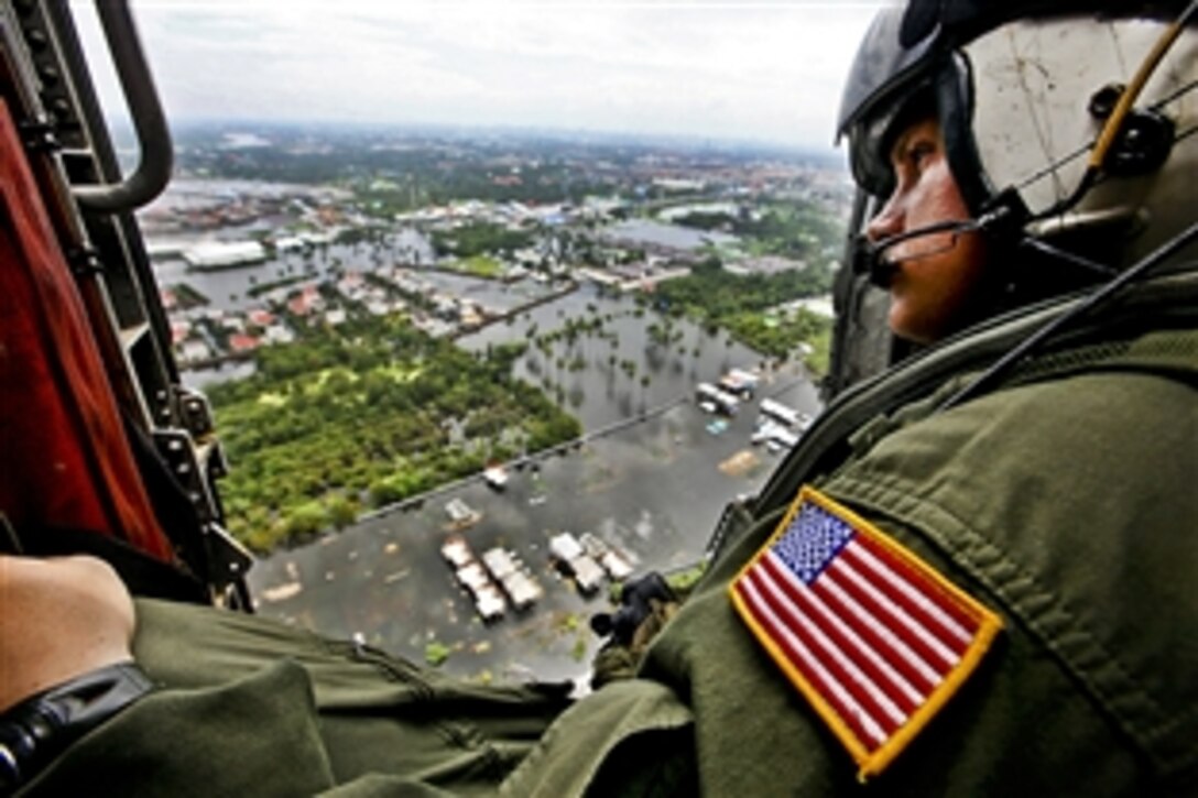 U.S. Navy Chief Petty Officer Nick Hall looks at flooded neighborhoods during an aerial assessment of Pathum Thani, Sai Mai, and surrounding areas north of Bangkok, Oct. 28, 2011. Hall is a search and rescue corpsman assigned to Helicopter Anti-Submarine Squadron, and a member of the III Marine Expeditionary Force's humanitarian assistance survey team. An abnormal monsoon season has caused flooding which has affected 61 provinces and 8.2 million people.