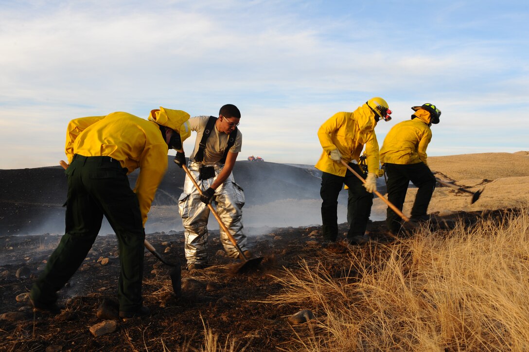 Firefighters dig a trench line to contain and stop a grassland fire north of Ellsworth Air Force Base, S.D., Nov. 3, 2011. Firefighters from several surrounding agencies worked into the night to extinguish the flames. (U.S. Air Force photo by Airman 1st Class Zachary Hada/Released)