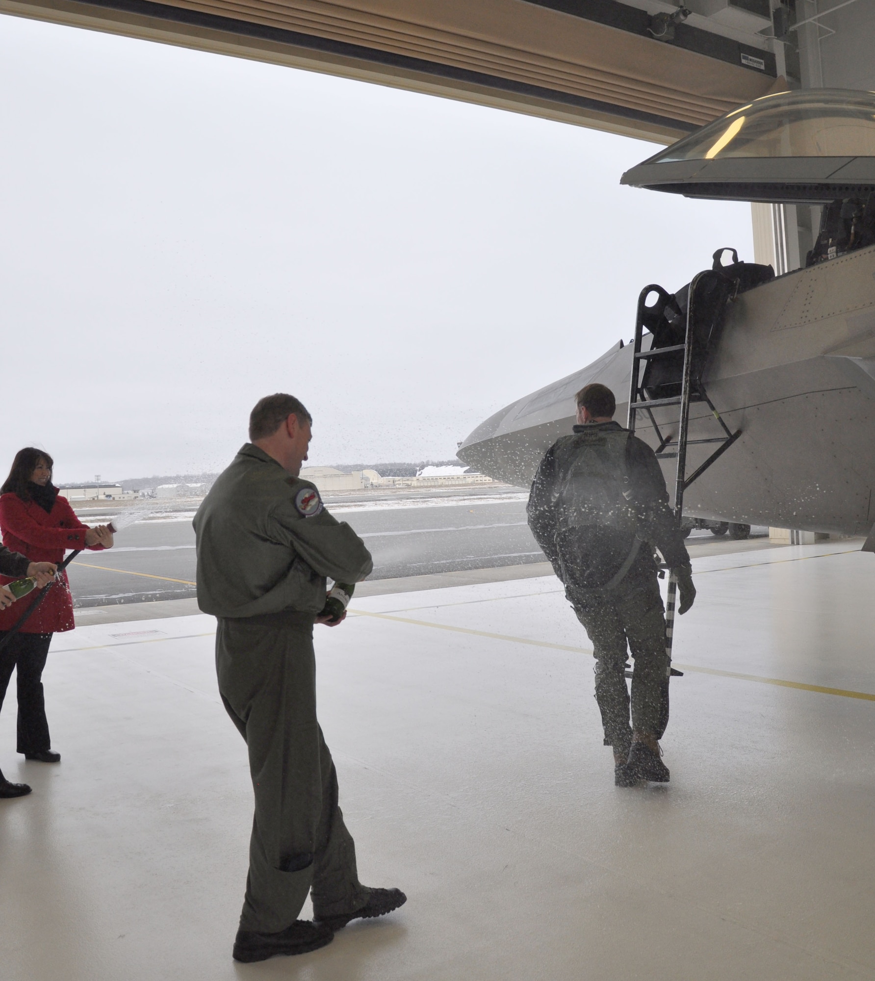 302nd Fighter Squadron commander is hosed down by his wife and  302nd Director of Operations, after completing 1,000 flight hours in the F-22.