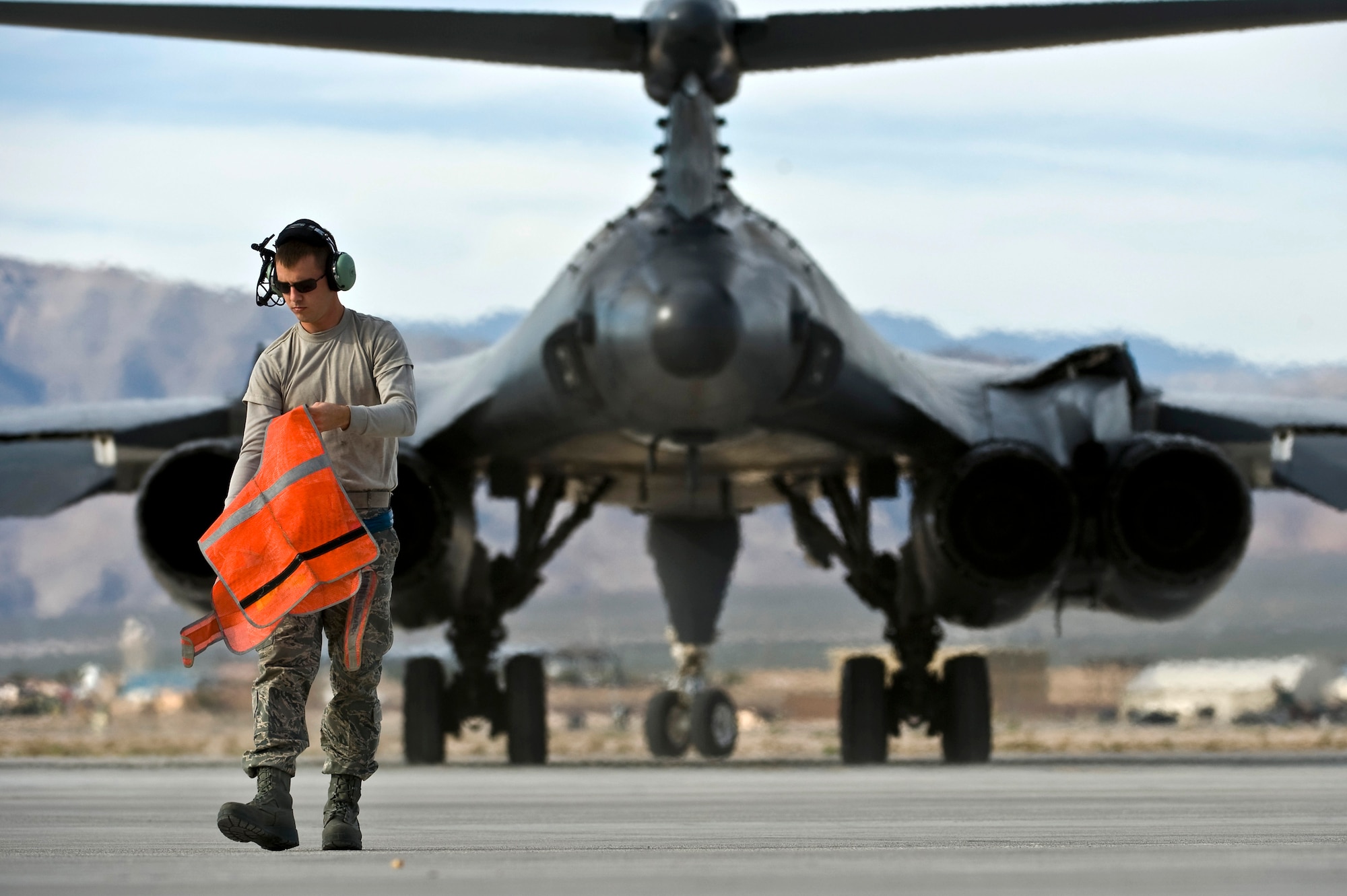 U.S. Air Force Airman 1st Class Ryan Wagoner, 7th Aircraft Squadron crew chief, Dyess Air Force Base, Texas, folds a safety vest after marshalling a B-1 Lancer during the integrated tactics phase of the U.S. Air Force Weapons School Nov. 3, 2011, at Nellis Air Force Base, Nev. The 77th Weapons Squadron, part of the U.S.A.F.W.S., provides instructional flying and tactics training for students piloting the B-1 Lancer. (U.S. Air Force photo by Senior Airman Brett Clashman/Released)
