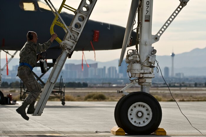 U.S. Air Force Staff. Sgt. Scott-Anthony McDaniels, communications navigation craftsman, 7th Aircraft Maintenance Squadron, Dyess Air Force Base, Texas, climbs up a B-1 Lancer ladder during the integrated tactics phase of the U.S. Air Force Weapons School Nov. 3, 2011, at Nellis Air Force Base, Nev. The 77th Weapons Squadron, part of the U.S.A.F.W.S., provide instructional flying and tactics training for students piloting the B-1 Lancer. (U.S. Air Force photo by Senior Airman Brett Clashman/Released)