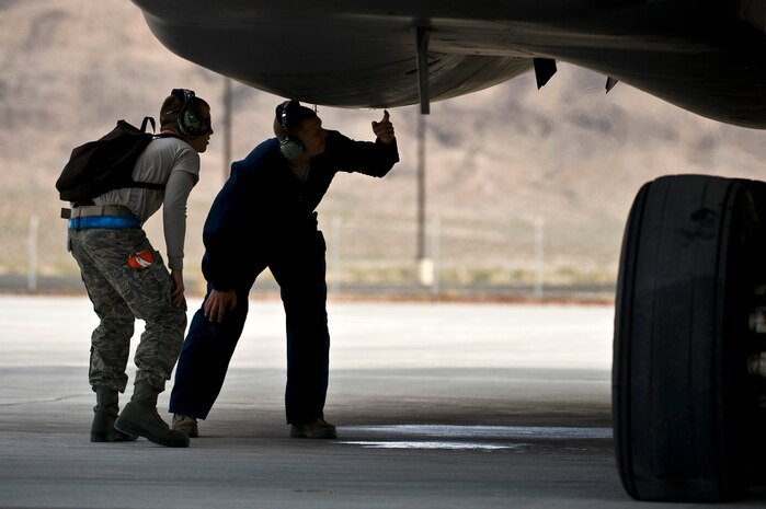 U.S. Air Force Airman 1st Class Ryan Wagoner and Tech. Sgt. Richard Townzen, crew chiefs, 7th Aircraft Maintenance Squadron, Dyess Air Force Base, Texas, inspect underneath a B-1 Lancer engine during the integrated tactics phase of the U.S. Air Force Weapons School Nov. 3, 2011, at Nellis Air Force Base, Nev. The 77th Weapons Squadron, part of the U.S.A.F.W.S., provide instructional flying and tactics training for students piloting the B-1 Lancer. (U.S. Air Force photo by Senior Airman Brett Clashman/Released)