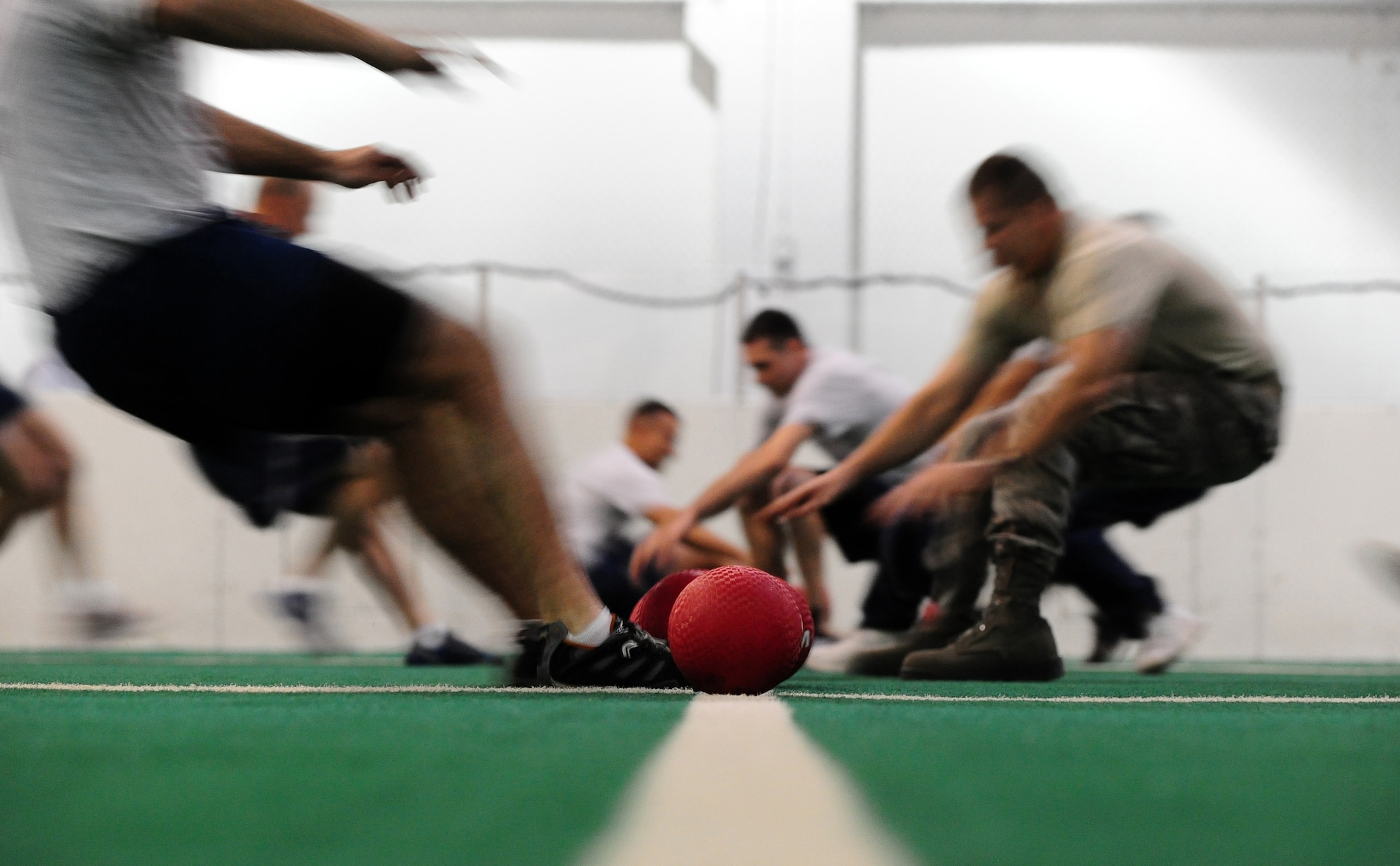 U.S. Air Force Airmen rushed to the line of dodgeballs waiting to be plucked from the ground and hurled at one another in the Field House indoor soccer field at Offutt Air Force Base, Neb., Nov. 4.  The dodgeball tournament was just one of the scheduled events during Wingman Day, where Airmen get to participate in team building activities and sports.  (U.S. Air Force photo by Josh Plueger/Released)