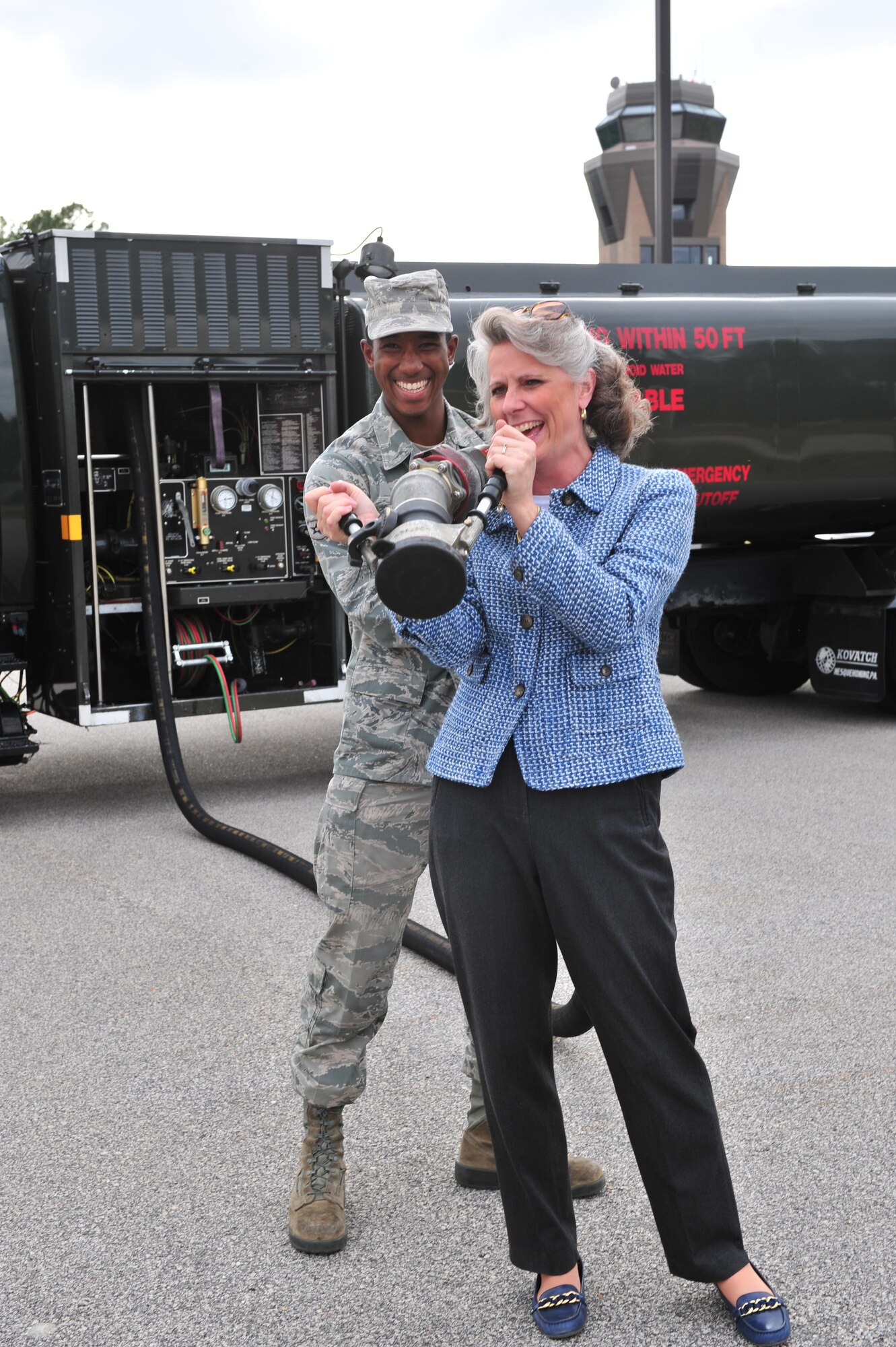 Mrs. Kathy Wells, wife of 9th Air Force commander, Maj. Gen. Lawrence Wells, holds a fuel hose for a Kovatch International Refueler while Airman 1st Class Dionte Jones, 20th Logistics Readiness Squadron fuels distribution apprentice, helps Nov. 3, 2011, Shaw Air Force Base, S.C. General Wells and his wife visited the 20th Fighter Wing after assuming command of 9th Air Force two weeks prior. (U.S. Air Force photo by Airman 1st Class Amber E. N. Jacobs/Released) 