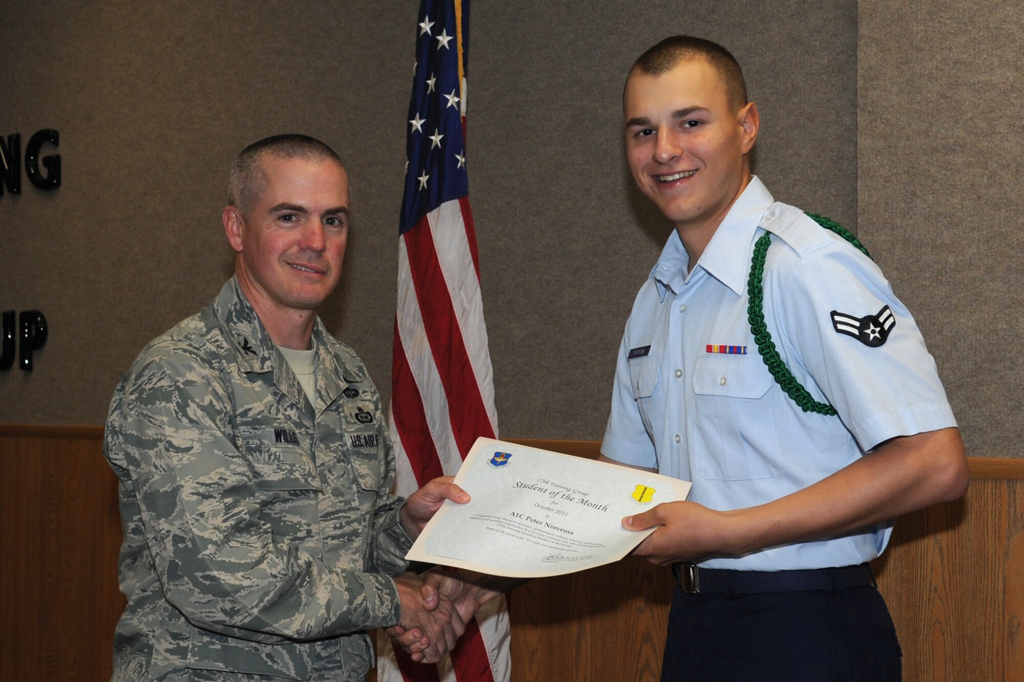 GOODFELLOW AIR FORCE BASE, Texas -- Col. JD Willis, 17th Training Group Commander, presents Airman 1st Class Peter Norcross with the 315th Training Squadron Enlisted Student of the Month award for October, Nov. 4. (U.S. Air Force photo/Staff Sgt. Laura R. McFarlane)