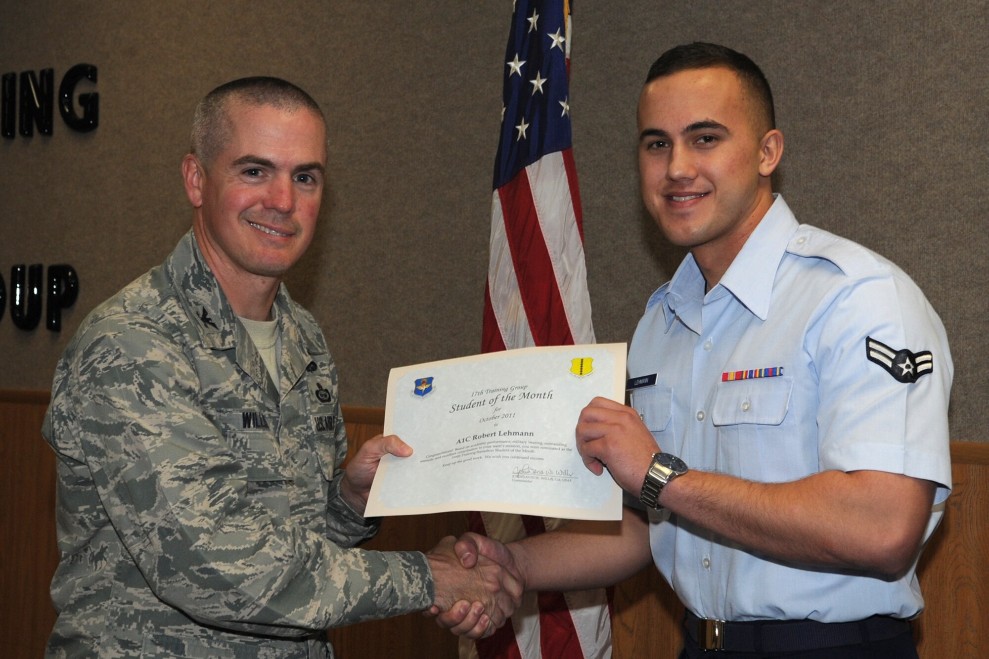 GOODFELLOW AIR FORCE BASE, Texas -- Col. JD Willis, 17th Training Group Commander, presents Airman 1st Class Robert Lehmann with the 316th Training Squadron Student of the Month award for October, Nov. 4. (U.S. Air Force photo/Staff Sgt. Laura R. McFarlane)