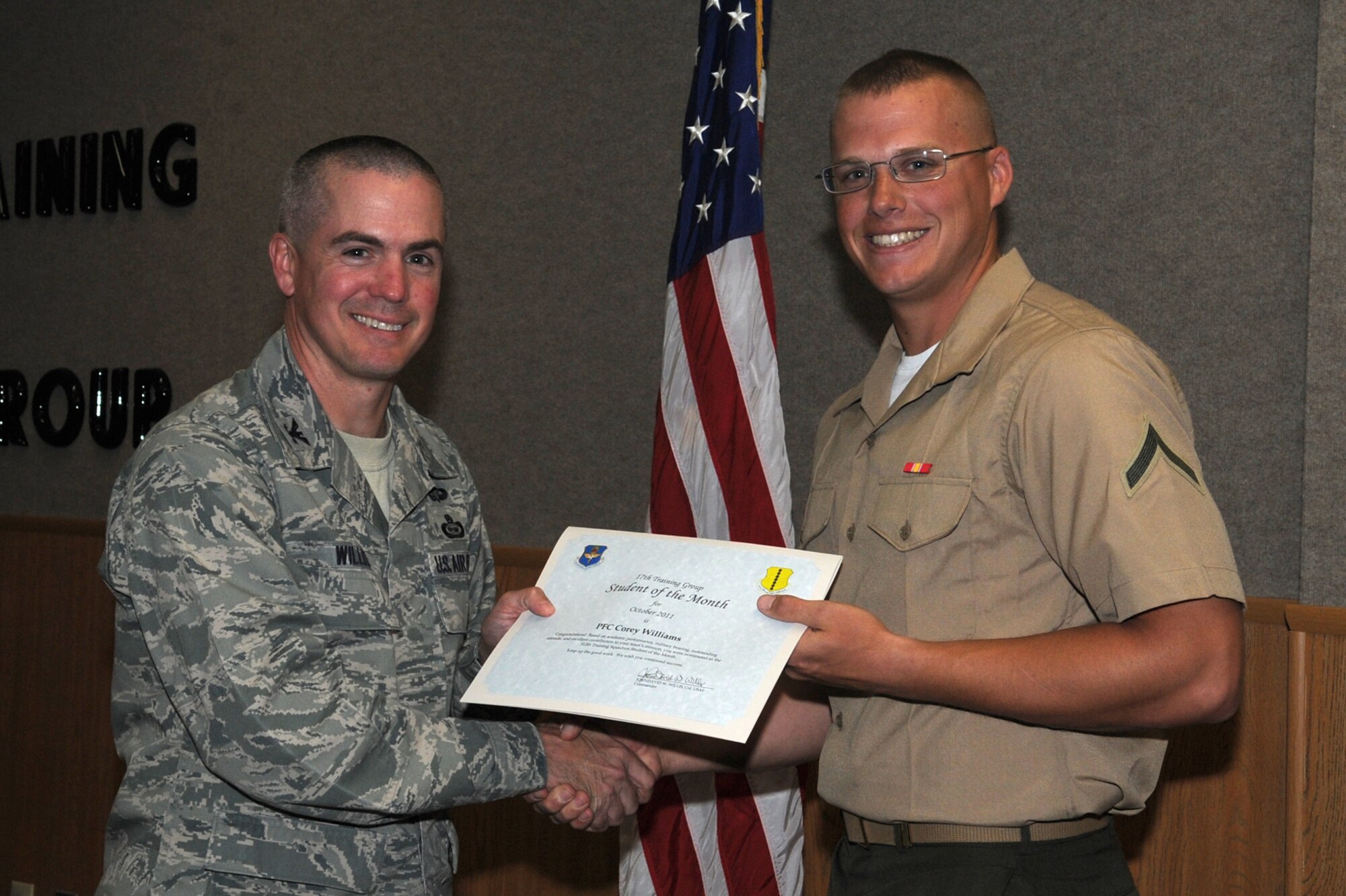 GOODFELLOW AIR FORCE BASE, Texas -- Col. JD Willis, 17th Training Group Commander, presents Marine Pfc. Corey Williams with the 312th Training Squadron Student of the Month award for October, Nov. 4. (U.S. Air Force photo/Staff Sgt. Laura R. McFarlane)
