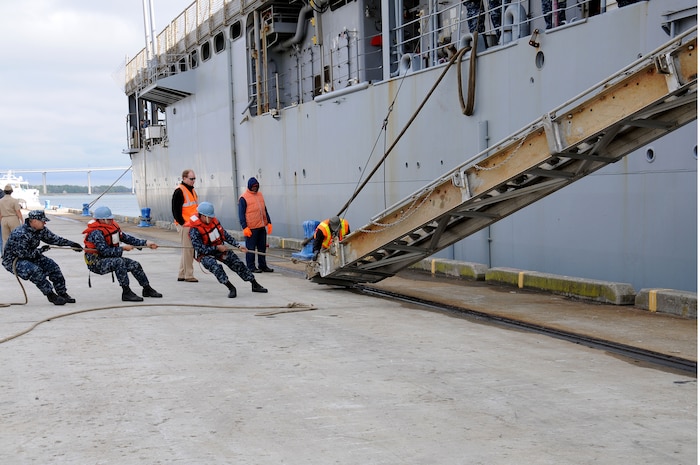 Civilian port workers and Sailors move the USS Gunston  Hall’s (LSD 44) accommodation ladder into place at Union Pier, downtown Charleston, Nov. 4. The ship’s crew will be conducting training with more than 80 Citadel Naval Reserve Officer Training Corps Midshipmen. The Gunston Hall supports amphibious operations via helicopters, Landing Craft Air Cushion and conventional landing craft. (U.S. Navy photo/Petty Officer 1st Class Jennifer Hudson)