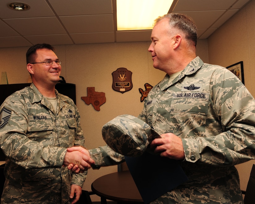 Senior Master Sgt. Jason Winegar shakes hands with Col. Erik Hansen after finding out he was one of five individuals from Joint Base Charleston to make Chief Master Sgt., Nov. 2, 2011. Winegar is the quality assurance superintendent with the 437th Maintenance Group and Hansen is the 437th Airlift Wing commander. (U.S. Air Force photo/Staff Sgt. Katie Gieratz)(Released)