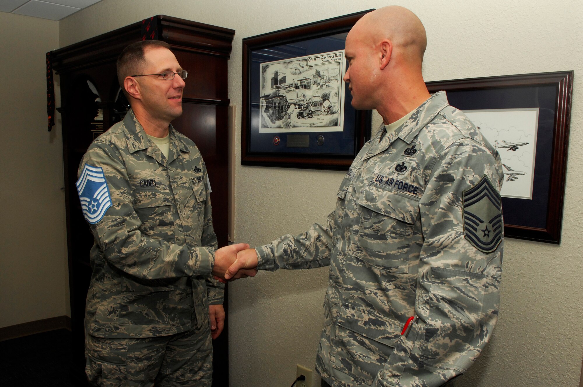U.S. Air Force Senior Master Sgt. Stanley Cadell, Air Force Central Command, gets coined and congratulated by Chief Master Sgt. Charles Campbell, AFCENT A6, Shaw Air Force Base, S.C. Nov.3, 2011. Several of Shaw’s chiefs visited different squadrons congratulating and welcoming the chief selects to the chief family. (U.S. Air Force photo by Airman 1st Class Ashley L. Gardner/ Released)