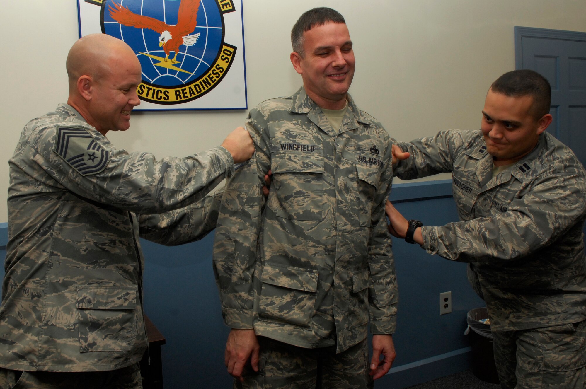 U.S. Air Force Senior Master Sgt. Bryon Wingfield, 20th Logistics Readiness Squadron vehicle maintenance manager, gets “tacked on” by Capt. Stephen Gallagher, 20th Logistics Readiness Squadron officer in charge and Chief Master Sgt. Charles Campbell, AFCENT A6, Shaw Air Force Base, S.C. Nov.3, 2011. Several of Shaw’s chiefs visited different squadrons congratulating and welcoming the chief selects to the chief family. (U.S. Air Force photo by Airman 1st Class Ashley L. Gardner/ Released)