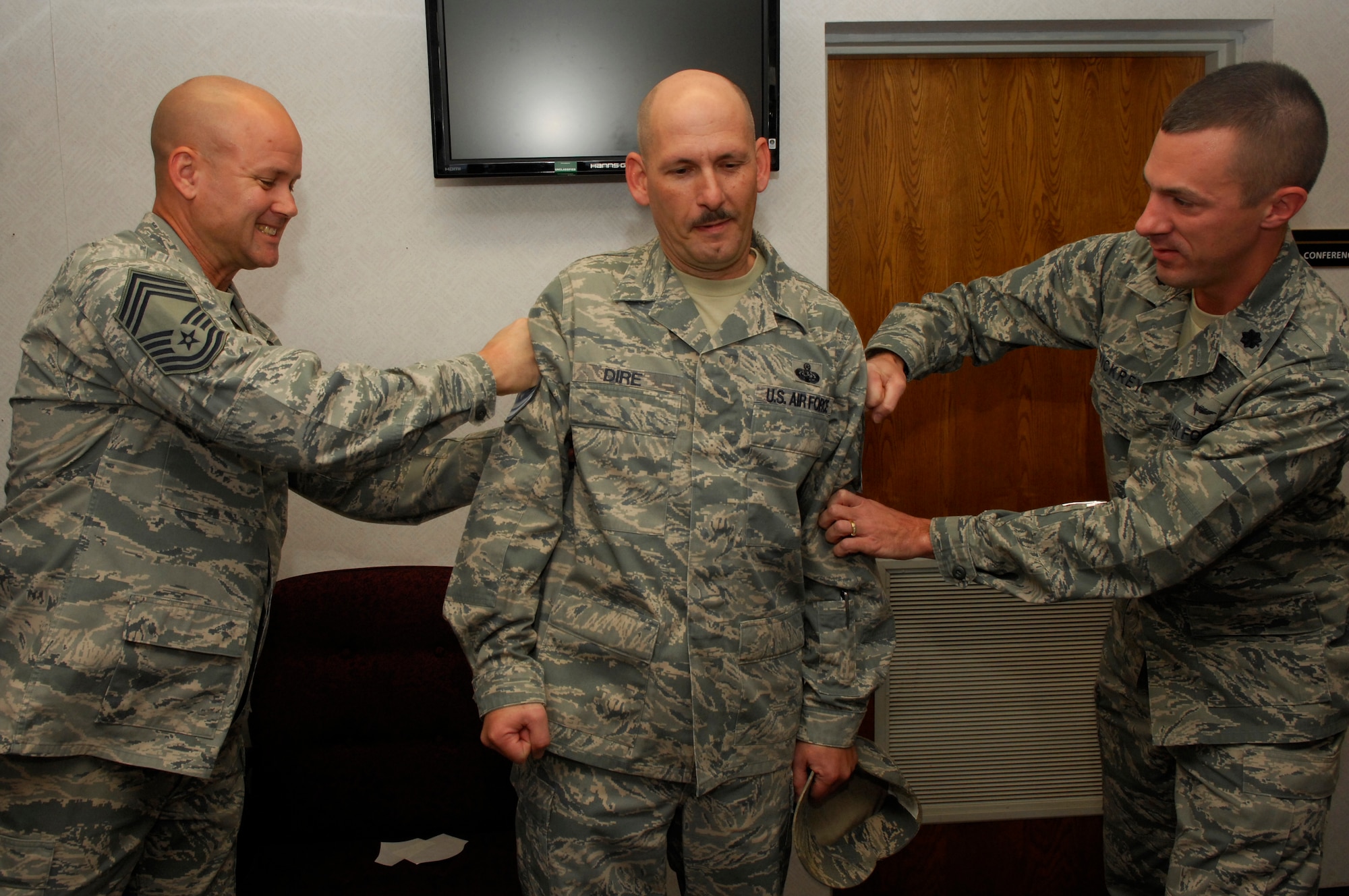 U.S. Air Force Senior Master Sgt. Jerry Dire, 20th Communications Squadron, gets “tacked on” by Lt. Col John Vickrey, Commander 20th Communications Squadron, and Chief Master Sgt. Charles Campbell, AFCENT A6, Shaw Air Force Base, S.C. Nov.3, 2011. Several of Shaw’s chiefs visited different squadrons congratulating and welcoming the chief selects to the chief family. (U.S. Air Force photo by Airman 1st Class Ashley L. Gardner/ Released)