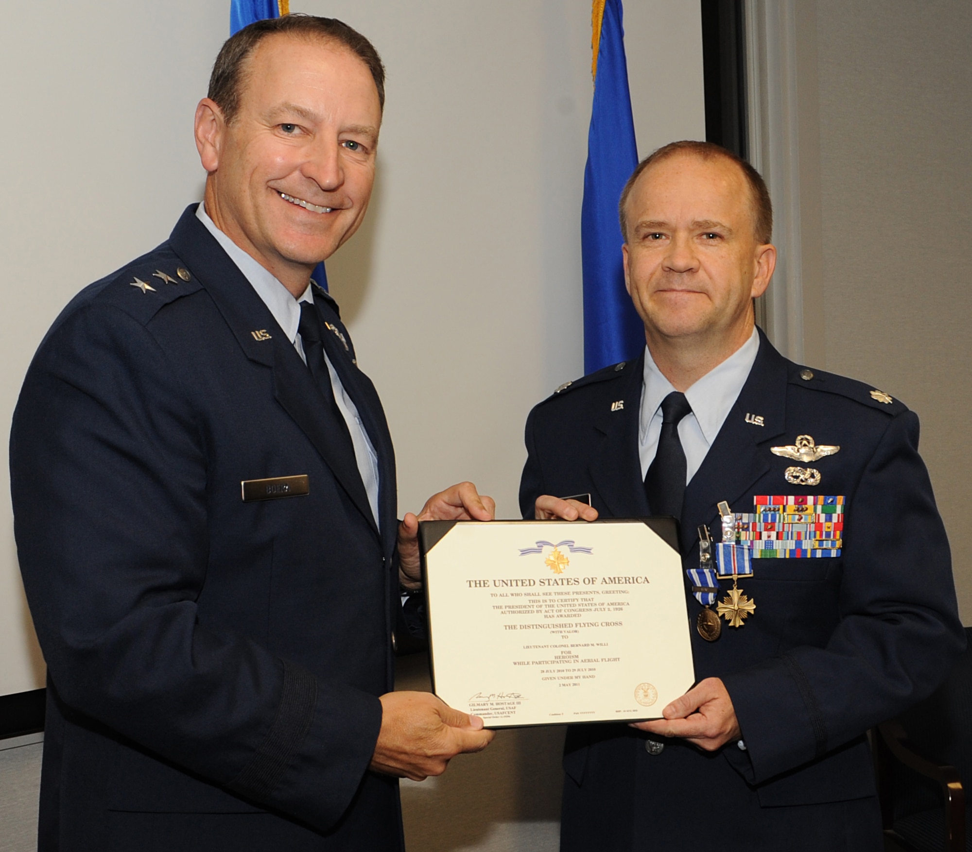 U.S. Air Force Maj. Gen. Michael Boera, Air Combat Command director of requirements, presents the Distinguished Flying Cross to Lt. Col. Bernard Willi, ACC Personnel Recovery Core Function Team chief, at Langley Air Force Base, Va., Oct. 31, 2011. Over a two day period of emergency rescue operations, Willi and an Afghan crew saved a total of 988 lives; including taking 64 people to safety in a single aircraft load. (U.S. Air Force photo by Airman 1st Class Teresa Cleveland/Released)