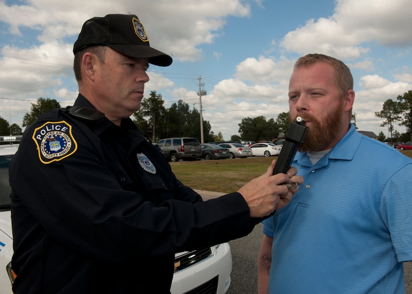 Retired U.S. Air Force Tech. Sgt. David Taylor, Department of the Air Force, and Robert Netherton, both from the 23rd Security Forces Squadron, perform a Breathalyzer demonstration Nov. 2, 2011, at Moody Air Force Base, Ga. The SFS highly encourages all Airmen to have a plan when drinking, and to call 229-25-SOBER (76237) if a safe ride home is needed. (U.S. Air Force photo by Senior Airman Eileen Meier/Released)