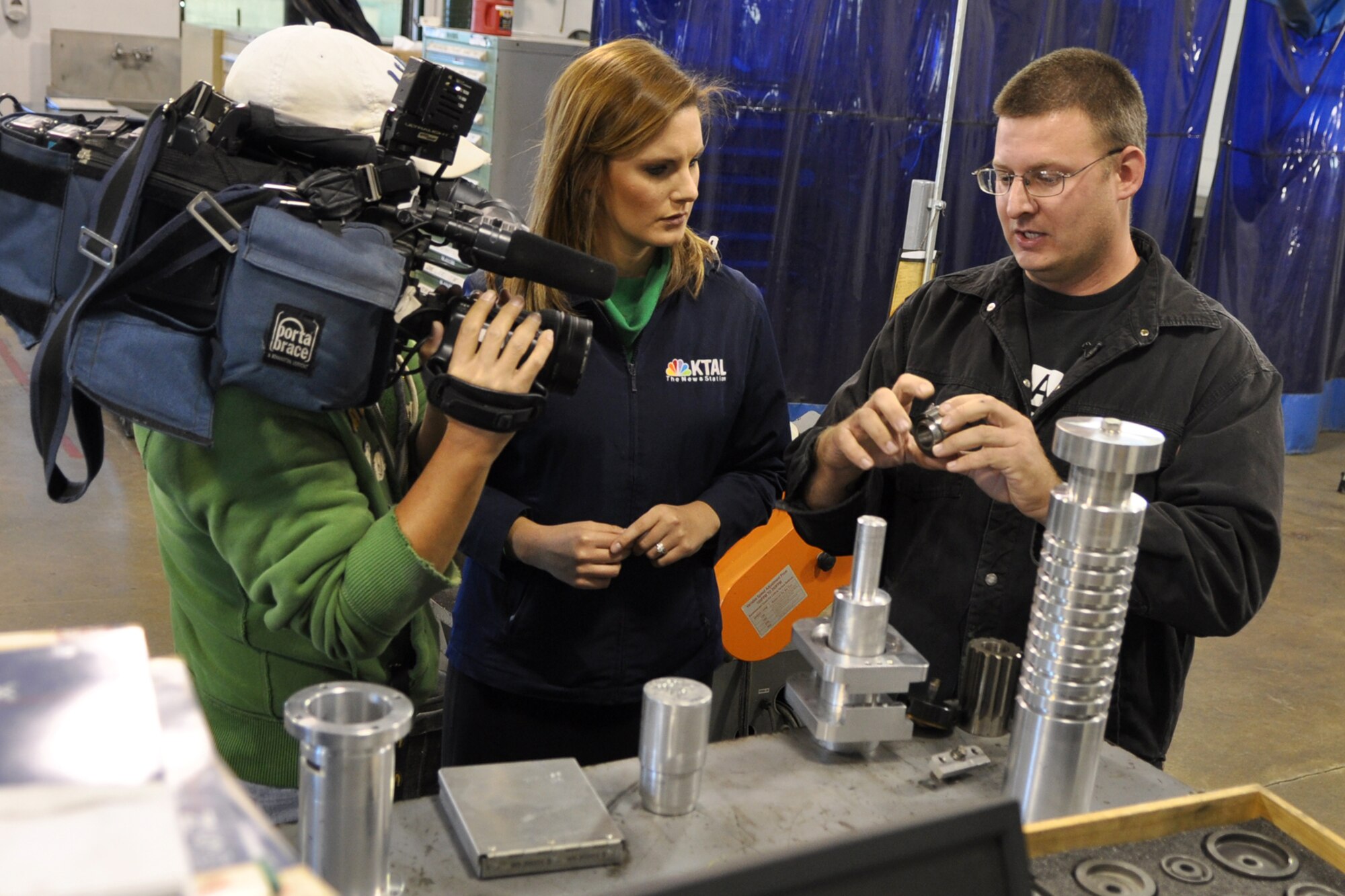 Zach Perry, who is an Air Reserve Technician (ART) assigned to the 917th Maintenance Squadron, explains a structural repair for an A-10 Thunderbolt II, to Jenna Zibton, and Chang Howang at the Metals Technology shop at Barksdale Air Force Base, La., Nov. 3, 2011. Zibton, who is a reporter for KTAL Channel 6 in Shreveport, La., and Howang, who is a cameraman for the station, were at Barksdale to report on the Reservists and their innovative aircraft repair methods that are saving American taxpayer dollars. Perry is also a Staff Sergeant in the Air Force Reserve and the aircraft metals technology supervisor. (U.S. Air Force photo by Master Sgt. Jeff Walston) 