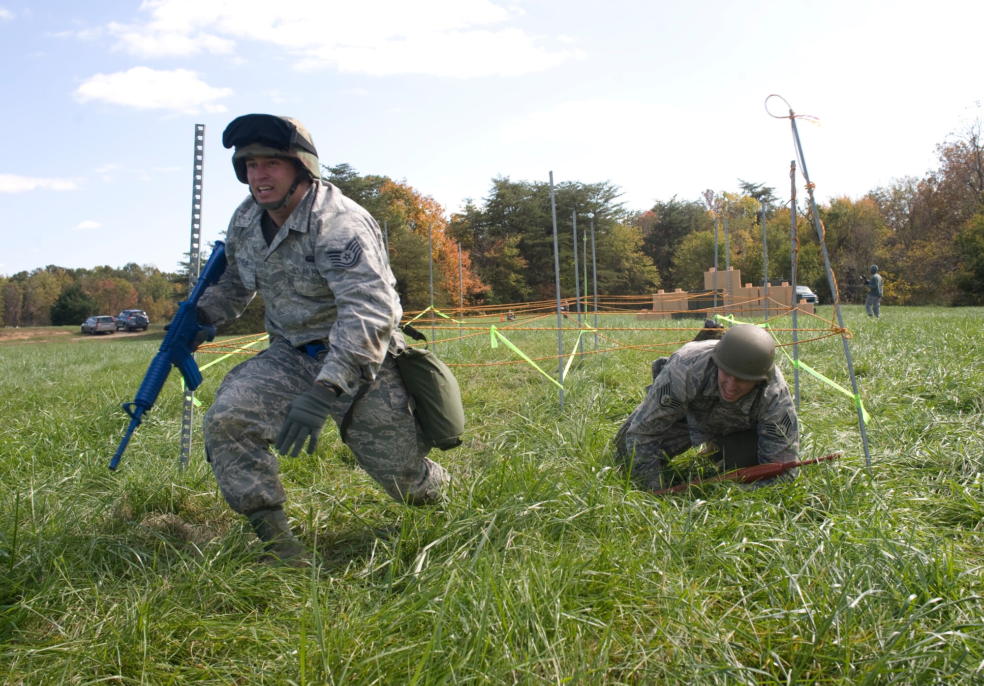 Technical Sgt. David Aceveda, 744th Communications Squadron NCO in charge of voice services, left, and Staff Sgt. Matt Bargas, 744th Communications Squadron global information facility shift supervisor, high crawl during the obstacle course portion of the annual 844th Communications Group Warrior Day Competition. (Photo by Bobby Jones)
