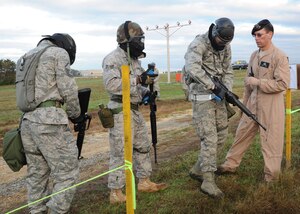 Airman 1st Class Carl Free, 744th Communications Squadron radio frequency transmissions systems technician; Senior Airman Jermaine Anderson, 744th CS official floor lead; and Master Sgt. Keith Moss, 744th CS quality assurance evaluator, ready their M-16’s under the supervision of Master Sgt. Eric Marsh, 11th Security Forces Group NCO in charge of training, as they head toward their defensive fighting positions during the annual 844th Communications Group Warrior Day Competition on Oct. 21. During this portion of the warrior day, 11th Wing Security Forces acted as opposing forces and led strategic attacks on the DFPs. (U.S. Air Force photo/Airman 1st Class Bahja J. Jones)