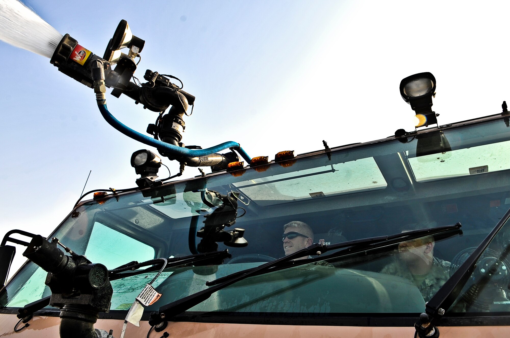 Chief Master Sgt. William Harner, 379th Air Expeditionary Wing command chief master sergeant, controls the nozzle of an Oshkosh Striker P-19 crash truck Nov. 2, 2011, at an undisclosed location in Southwest Asia. The Striker holds up to 1,500 gallons of water. (U.S. Air Force photo/Senior Airman Paul Labbe)