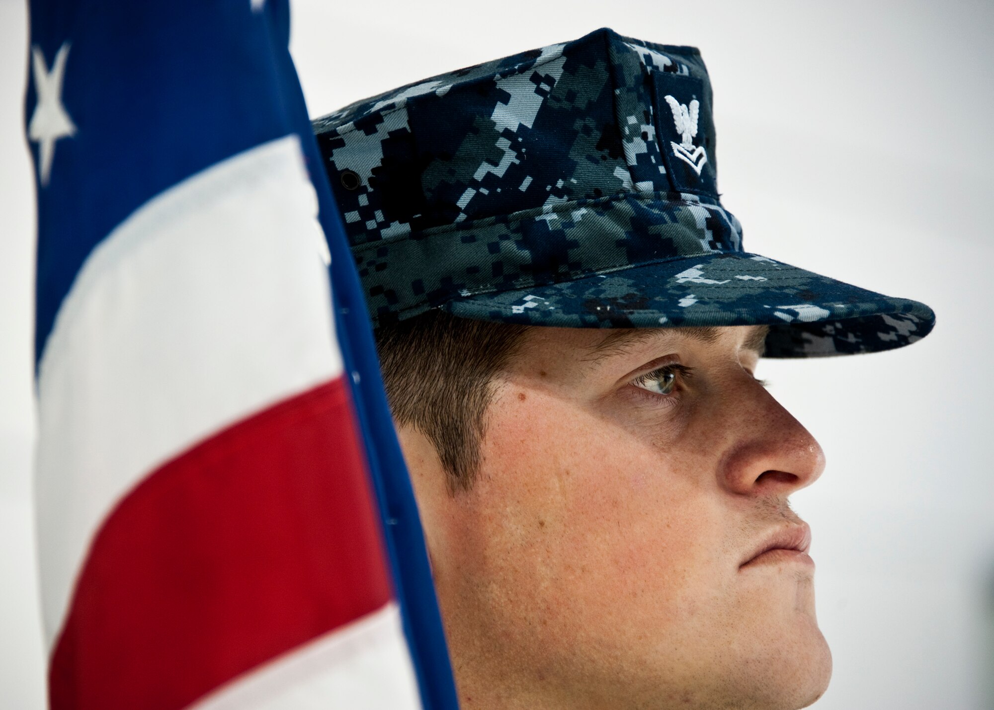 Petty Officer 2nd Class James Peters, an aviation ordnanceman with the VFA-101 Strike Fighter Squadron, stands at-the-ready to carry the American flag during his team’s first performance as a joint color guard at Eglin Air Force Base, Fla., Nov. 2. Airmen and Sailors trained for a month to provide a joint-service color guard for a recent 33rd Fighter Wing squadron change of command.  (U.S. Air Force photo/Samuel King Jr.)