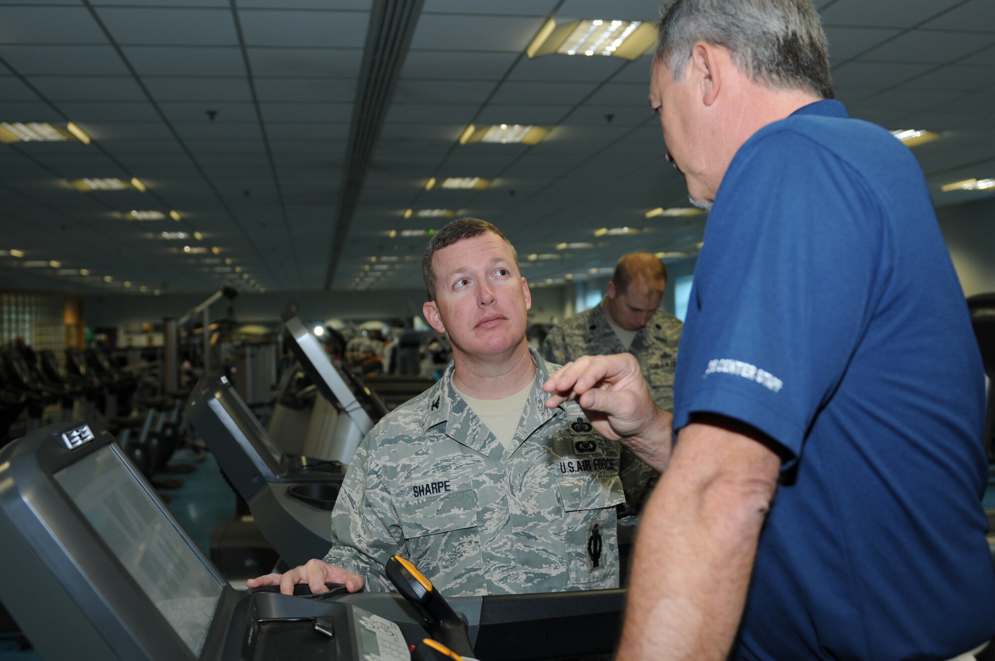 ROYAL AIR FORCE LAKENHEATH, England - Col. Christopher Sharpe, U.S. Air Forces in Europe director of manpower, personnel and services, and John Enterman, 48th Force Support Squadron fitness center athletic director, talk about new equipment in the fitness center during a tour, Nov. 2, 2011. Sharpe visited the base to view the 48th Force Support Squadron facilities and personnel. (U.S. Air Force photo by Airman 1st Class Cory D. Payne)