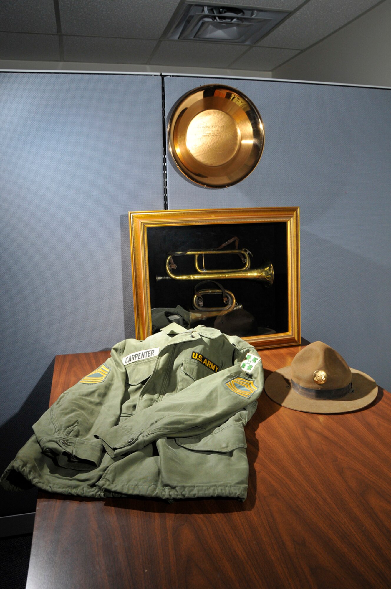 Her grandfather’s World War I bugles and hat, her uncle’s Army jacket and a commemorative gold pan that belonged to her aunt adorn Jeannie Bowden’s office at AEDC. (Photo by Rick Goodfriend)