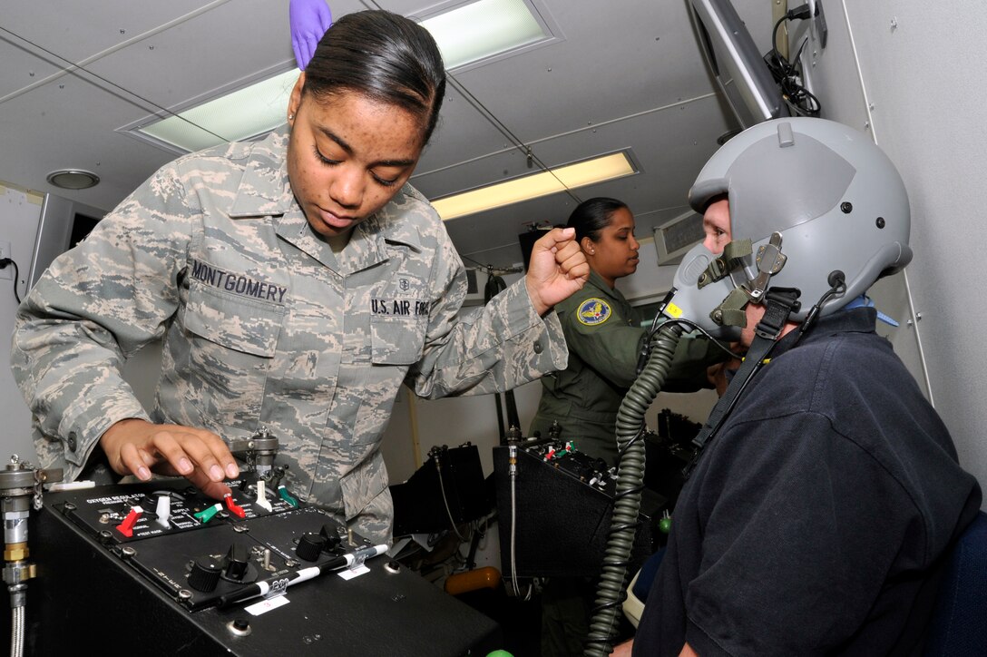 Senior Airman Tamika Montgomery, 779th Aerospace Medicine Squadron aerospace physiology technician, ensures a student’s flight helmet and mask fit properly and is receiving oxygen during their chamber flight Nov. 2. The Aerospace and Operational Physiology Training Flight uses the hypobaric chamber to train military, Department of Defense civilians and contractors on the effects of hypoxia, how to recognize their personal symptoms of hypoxia, and make the necessary corrections to reverse the symptoms of the condition. (U.S. Air Force photo/Senior Airman Perry Aston)