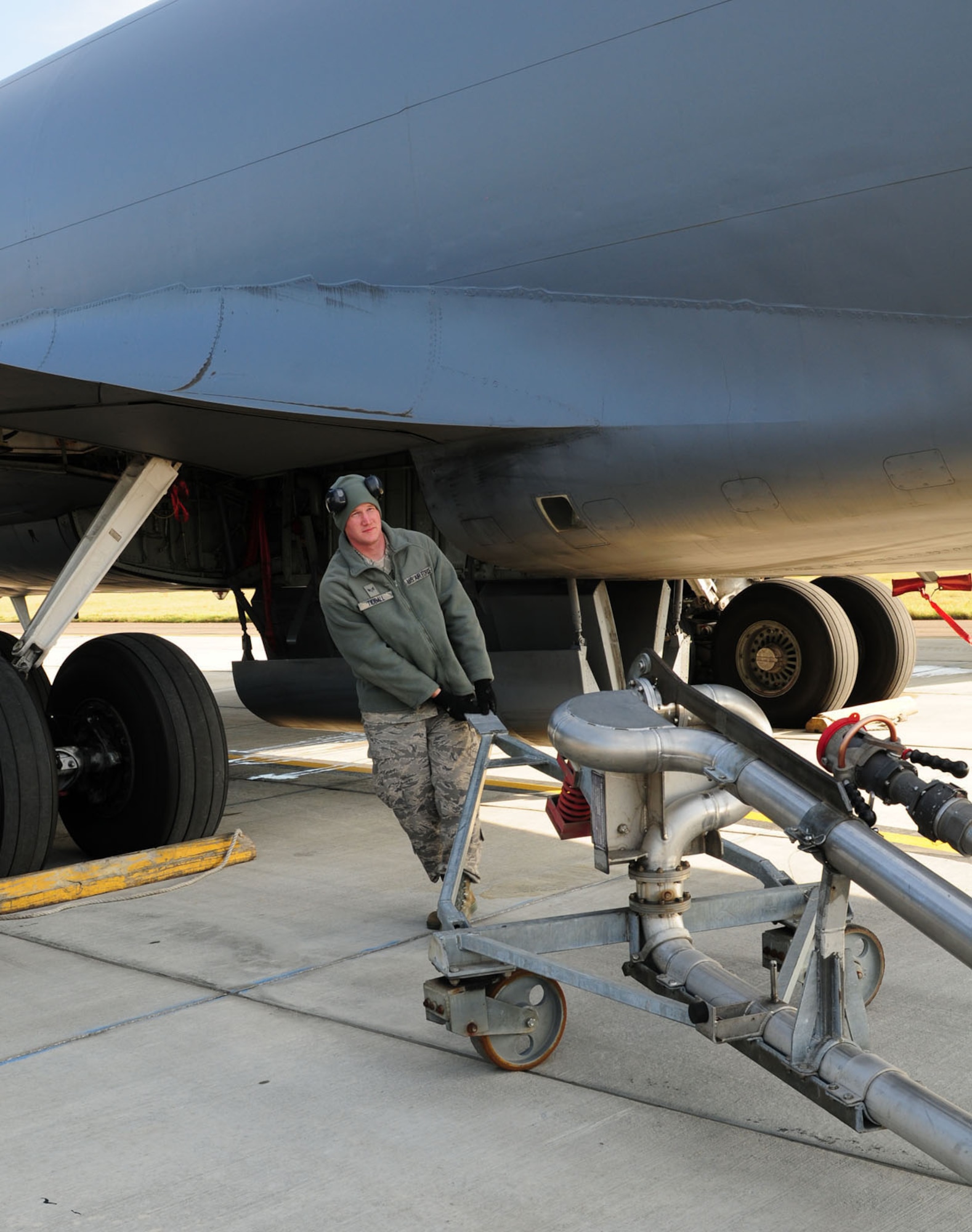RAF MILDENHALL, England -- Senior Airman Matthew Tidball, 100th Logistics Readiness Squadron fuels distribution operator, moves a fuel transport assembly (pantograph) into position underneath a transient KC-135 Stratotanker here Oct. 24, 2011. Once the pantograph is put into position, it is connected to the hydrant outlet and the aircraft before pumping fuel. (U.S. Air Force photo/Karen Abeyasekere)