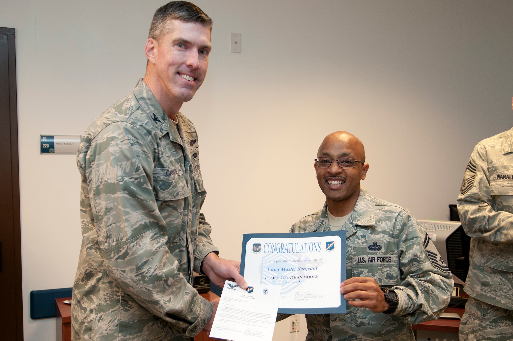 Senior Master Sgt. Jonathan Moore, right, 39th Communications Squadron, receives a congratulatory certificate from Col. Chris Craige, 39th Air Base Wing commander, Oct. 3, 2011, at Incirlik Air Base, Turkey. Moore has been selected for promotion to chief master sergeant, the Air Force's highest enlisted rank. (U.S. Air Force photo by Tech. Sgt. Michael B. Keller/Released)