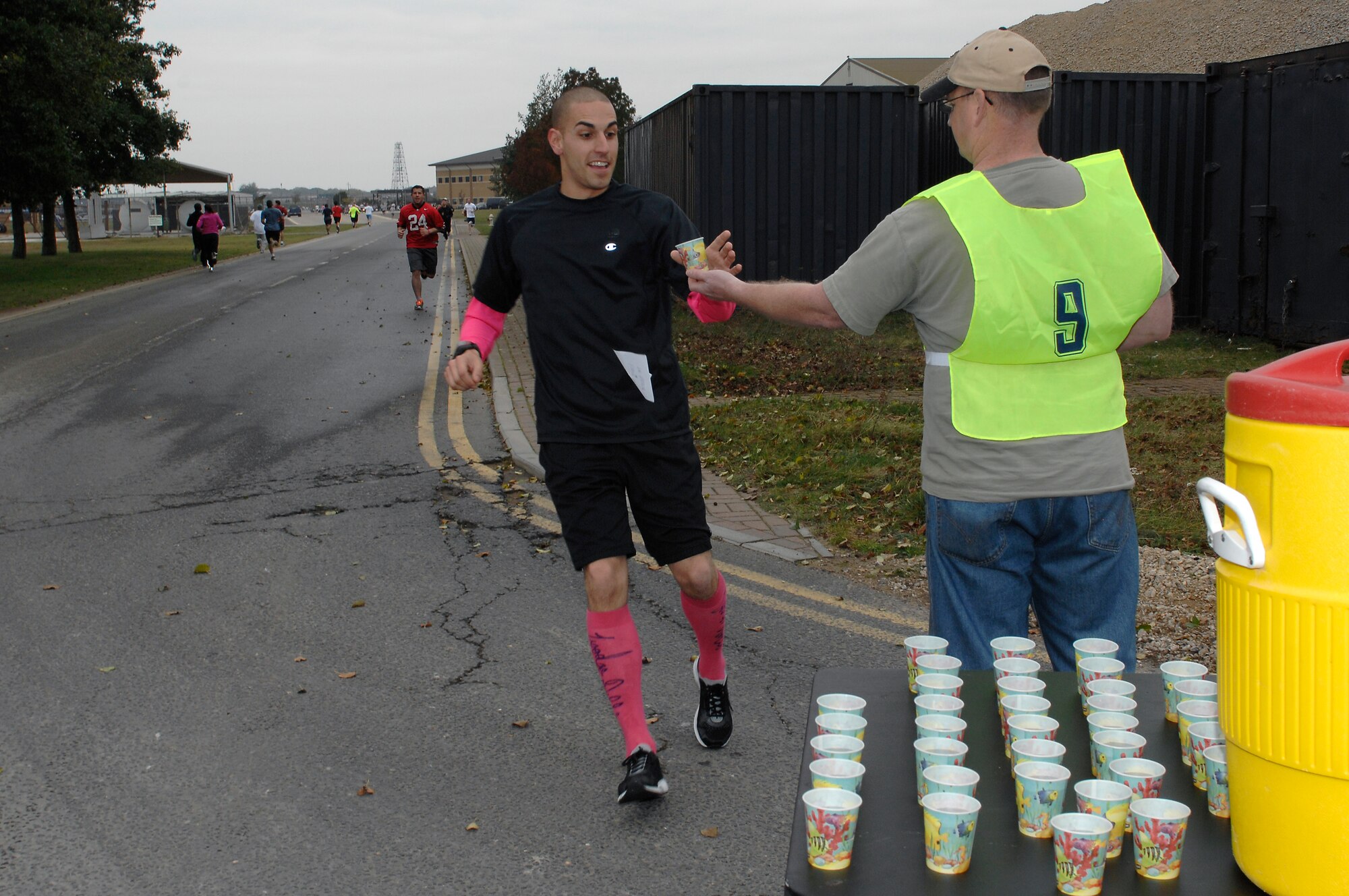 ROYAL AIR FORCE LAKENHEATH, England--Tech. Sgt. Matthew Perry, 48th Equipment Maintenance Squadron repair and reclamation section chief, grabs a quick drink at the half-way point during a breast cancer awareness run and walk event Oct. 29, 2011. The Lakenheath Officer and Enlisted Civilian Spouses clubs hosted the event to help raise money during Combined Federal Campaign.  Over 170 participants turned out and all proceeds went to Susan G. Komen for the Cure.  (U.S. Air Force photo by Tech. Sgt. Lee A. Osberry Jr.)