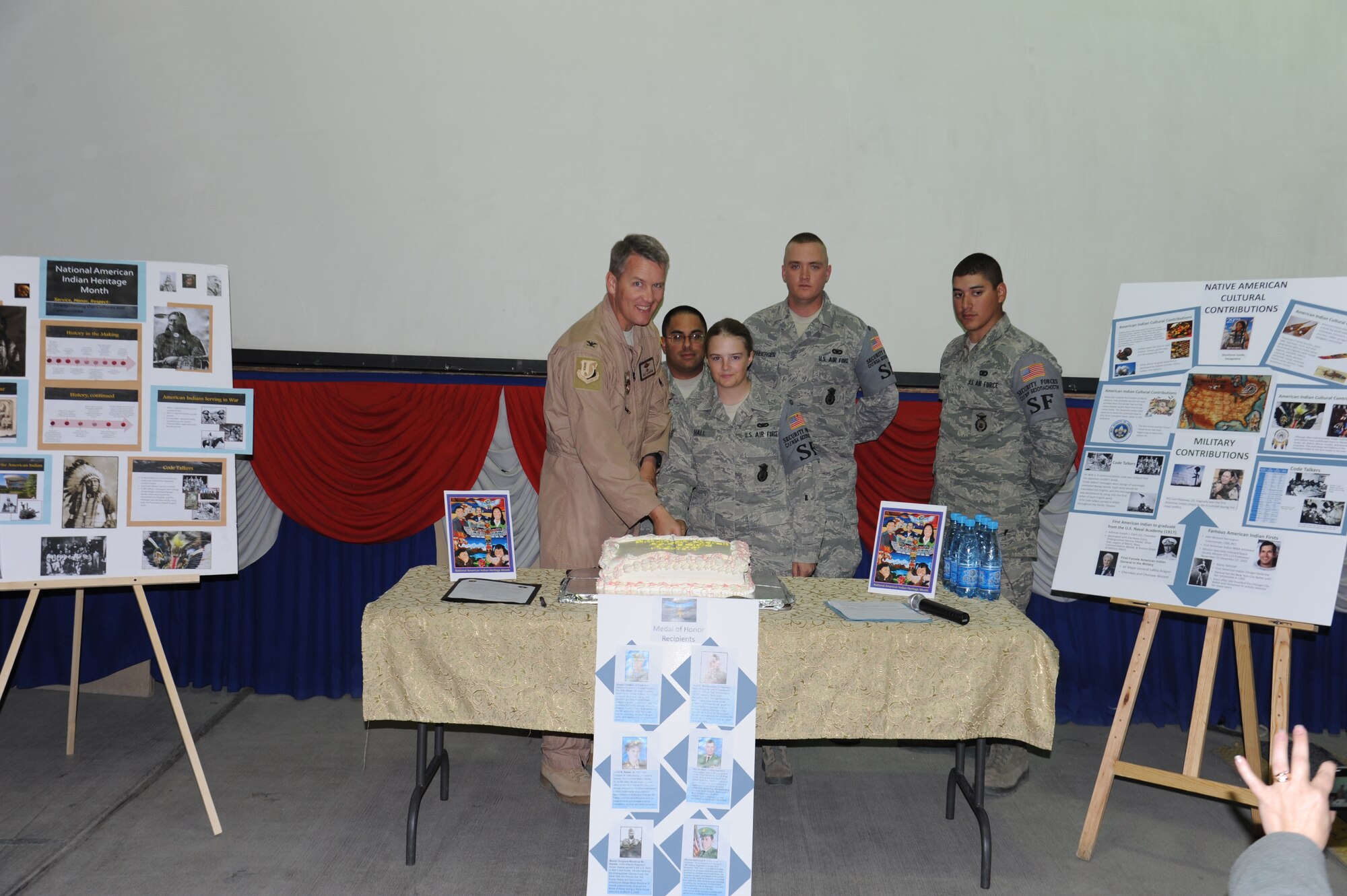 Col. James Jacobson and Senior Airman Rebecca Hall make the first cut in the cake as members of the First Four committee look on during a ceremony marking Native American History Month at the Transit Center at Manas, Kyrgyzstan, Nov. 3. Native Americans have served as valuable members of the armed forces for many years. Native American code talkers were an invaluable military resource during World War II. Hall is a security controller assigned to the 376th Expeditionary Security Forces Squadron and is deployed from the 22nd Security Forces Squadron at McConnell Air Force Base, Kan. Jacobson is the commander of the 376th Air Expeditionary Wing. (U.S. Air Force photo/Tech. Sgt. Hank Hoegen)