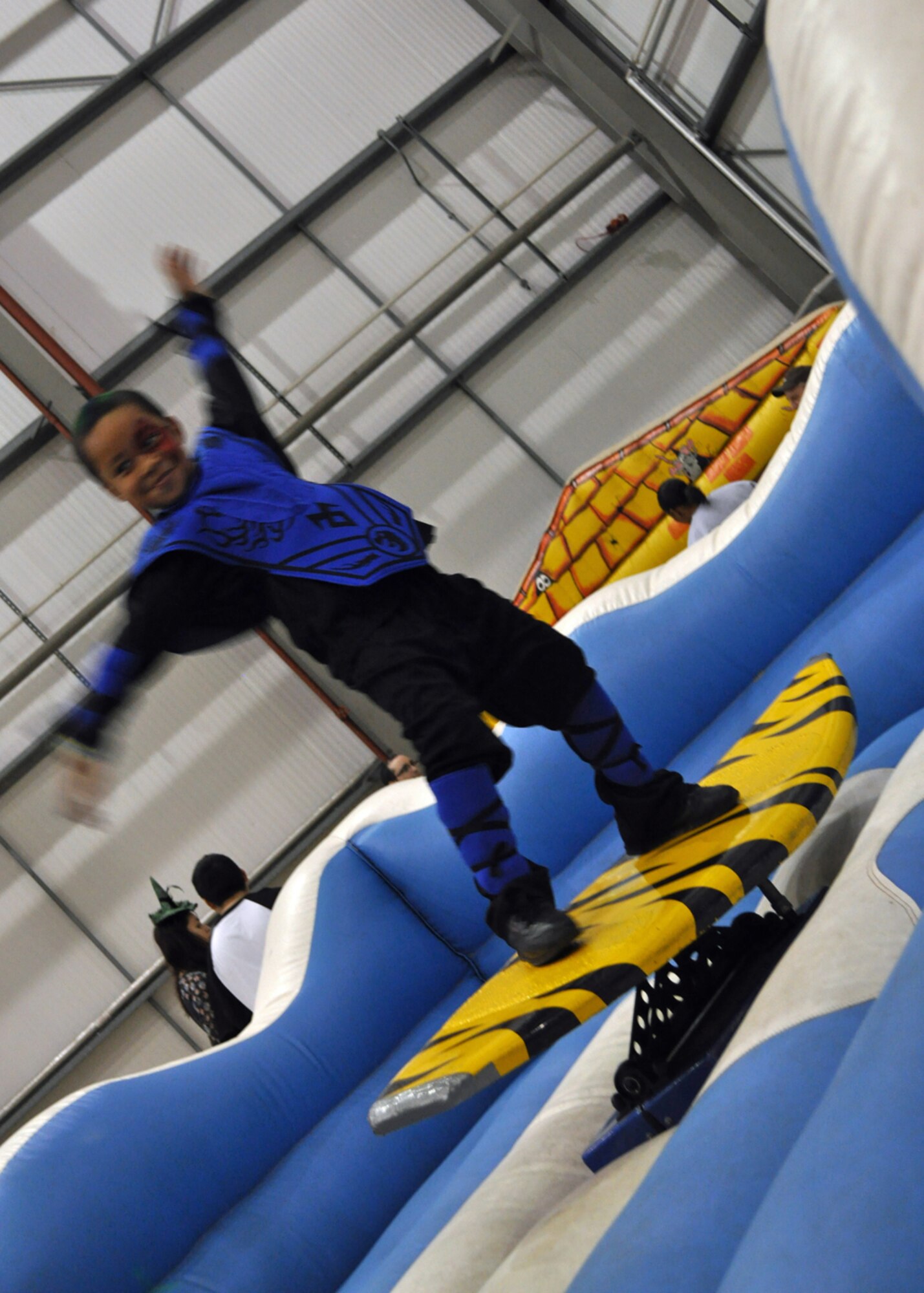 RAF MILDENHALL, England -- Five-year-old Savion Owens, son of Tech. Sgt. Jaclyn Owens, 352nd Special Operations Support Squadron, ‘hangs ten’ at the 352nd Special Operations Group's annual Fall Fest here, Oct. 29, 2011.  Each year the 352nd SOG Spouses' Group hosts the event to promote camaraderie within the unit.   (U.S. Air Force photo/Tech. Sgt. Marelise Wood)  