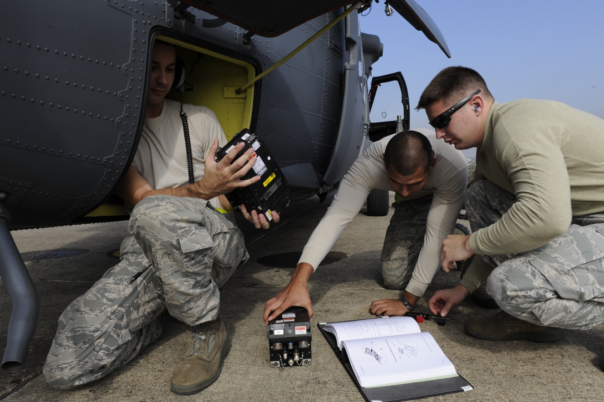 U.S. Air Force senior airmen Robert Park, Erwin Jara, and Gale Clary, 33rd Helicopter Maintenance Unit HH-60 crew chiefs, from Kadena Air Base, Japan, fix a maintenance issue on a Pave Hawk helicopter after a flight during exercise Pacific Thunder Nov. 1, 2011, near Osan Air Base, Republic of Korea. Pacific Thunder is a 10-day exercise, from Oct. 31 to Nov. 9 at Osan AB. The exercise involves the 33rd Rescue Squadron from Kadena AB, Japan, and the 25th Fighter Squadron from Osan. These units work together to practice combat search and rescue tactics to prepare for real-world emergency situations. (U.S. Air Force photo/Tech. Sgt. Angelique Bilog/released)

