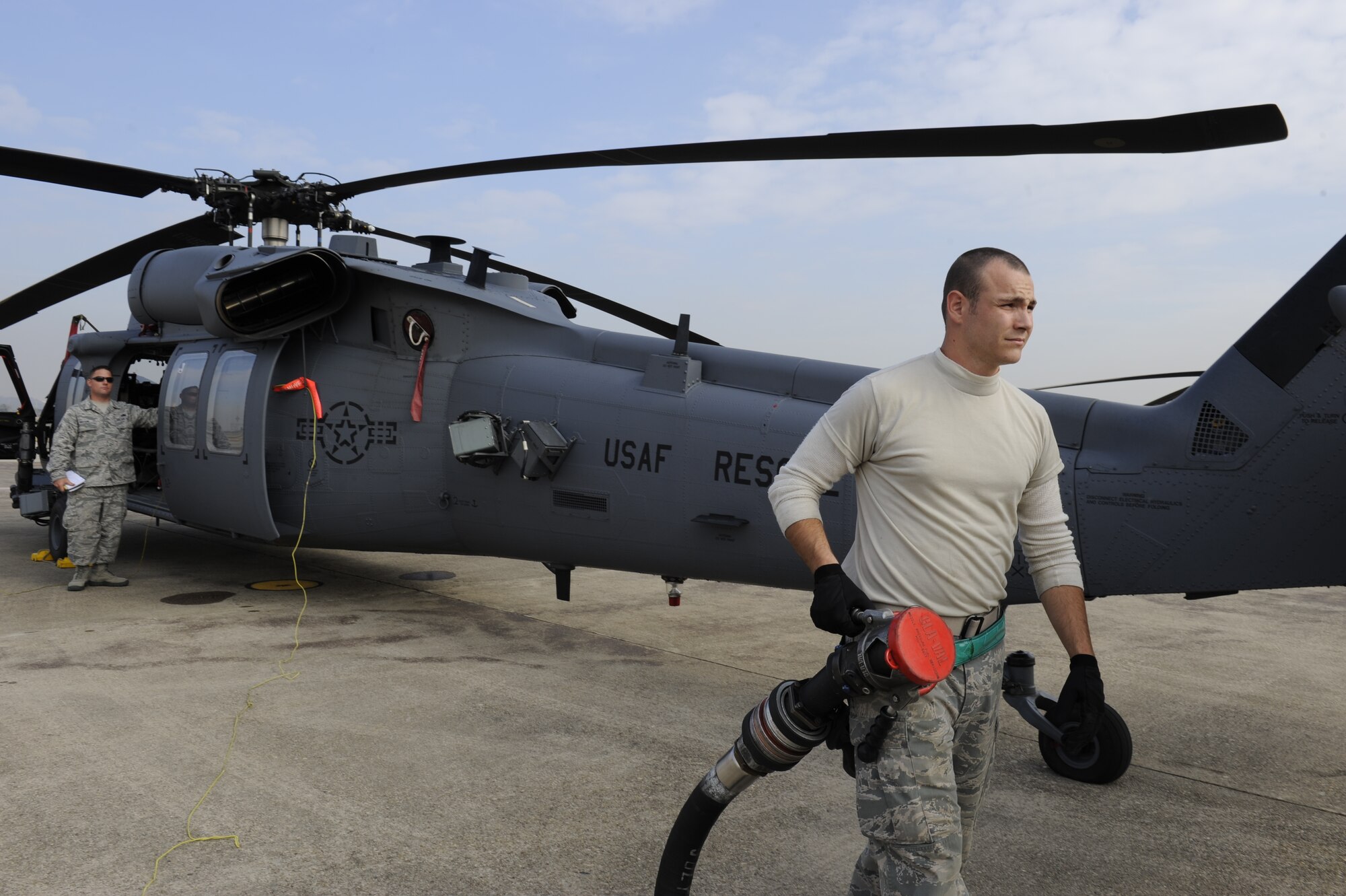 U.S. Air Force Senior Airman Dustin Unger, 33rd Helicopter Maintenance Unit HH-60 crew chief from Kadena Air Base, Japan, finishes refueling a Pave Hawk helicopter after a flight during exercise Pacific Thunder Nov. 1, 2011, near Osan Air Base, Republic of Korea. Pacific Thunder is a 10-day exercise, from Oct. 31 to Nov. 9 at Osan AB. The exercise involves the 33rd Rescue Squadron from Kadena AB, Japan, and the 25th Fighter Squadron from Osan. These units work together to practice combat search and rescue tactics to prepare for real-world emergency situations. 
(U.S. Air Force photo/Tech. Sgt. Angelique Bilog/released)


