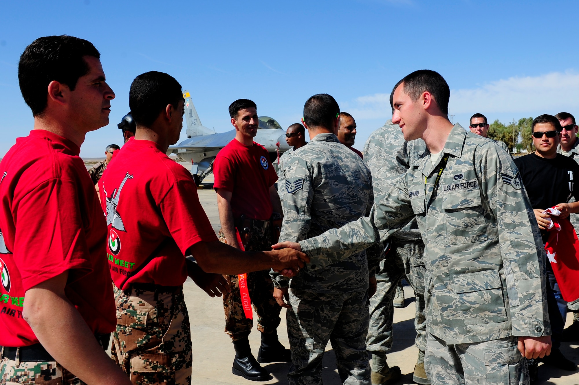 Air Force maintainers from Jordan and the U.S. greet prior to the start of a loading competition in support of Falcon Air Meet, Oct. 18, 2011. FAM is a multi-national exercise and operational activity in Jordan that enhances regional partnerships and interoperability as well as demonstrates U.S. commitment to regional security and stability. (U.S. Air Force photo/Senior Airman Asha Kin)