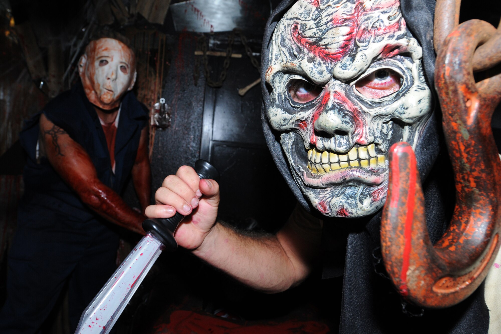 Senior Airman Matthew Moore and Airman 1st Class Joshua Smith, 36th
Civil Engineer Squadron 'Dirt Boyz' and house volunteers scare guests as
they travel through the house. The haunted house is a yearly event put on
by 36 CES volunteers and was open to all ages for enjoyment.  (U.S. Air
Force photo/Airman 1st Class Mariko Frazee)
