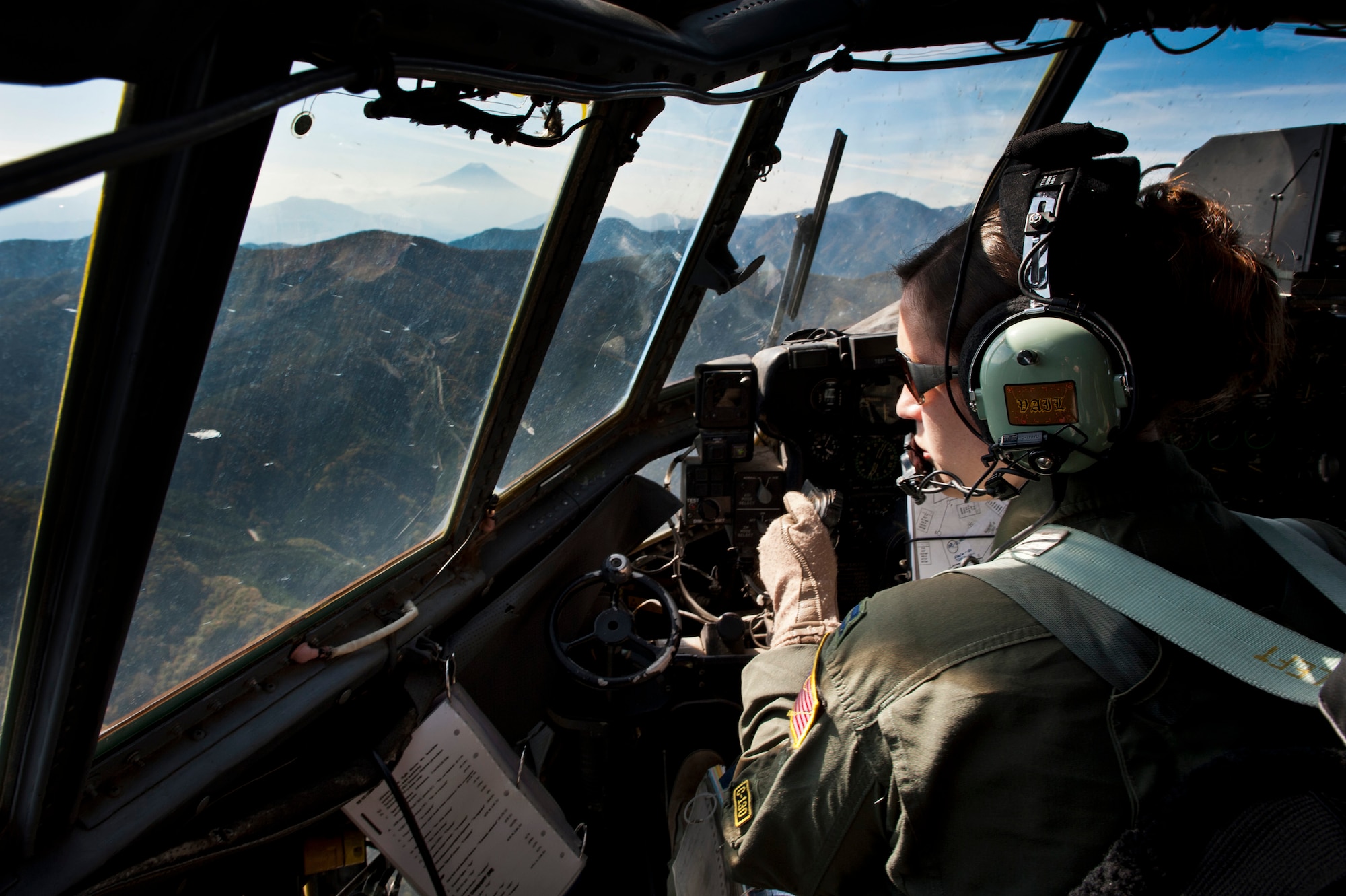 OVER JAPAN -- Capt. Heidi Pallister, 36th Airlift Squadron pilot, looks out her window while flying a C-130 Hercules through mountains near Mount Fuji, Japan, Nov. 2, 2011. Pallister's C-130 was the lead aircraft during the second half of the Samurai Surge, a training exercise involving formation flight and air drops. (U.S. Air Force photo/Staff Sgt. Samuel Morse)