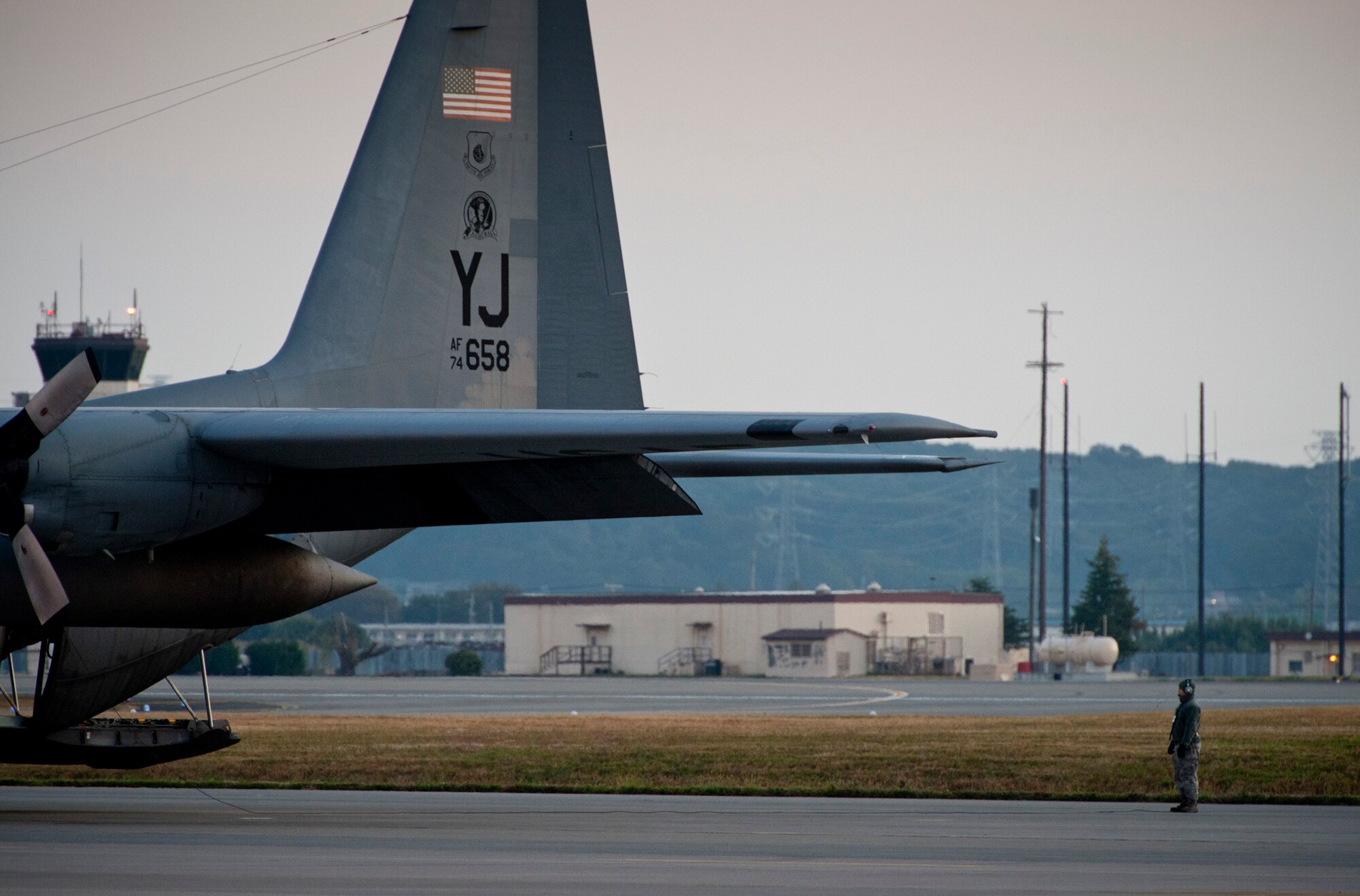YOKOTA AIR BASE, Japan -- A crewchief watches the wings of a C-130 Hercules during pre-flight checks at Yokota Air Base, Japan, Nov. 2, 2011. Maintenance crews prepared six C-130s to fly formation air drop training missions, known as a Samurai Surge, over Yokota Air Base and a drop zone near Mount Fuji. (U.S. Air Force photo/Staff Sgt. Samuel Morse)
