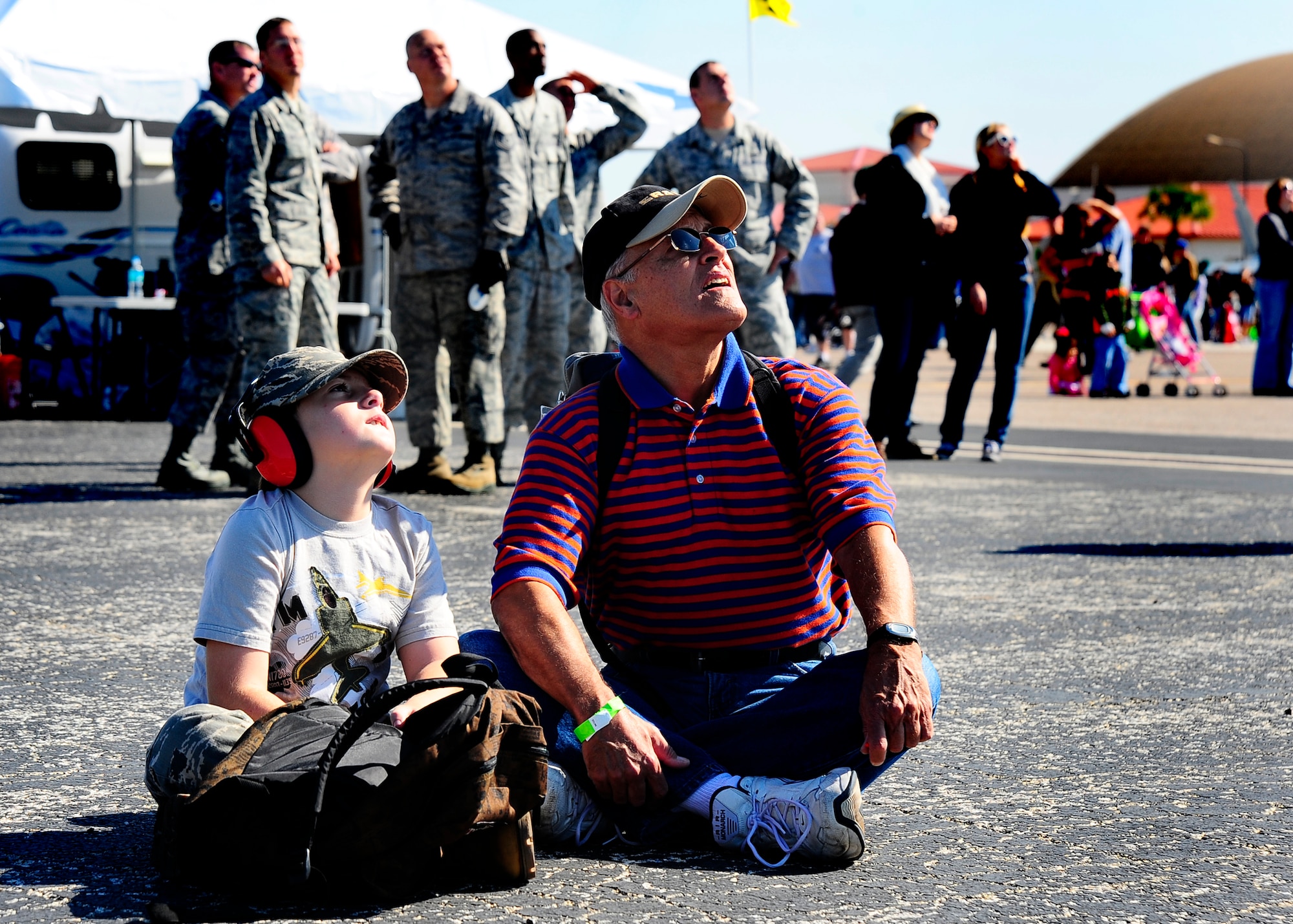 Ethan Gutterson watches the sky with his grandfather Al Rodriguez during AirFest on MacDill Air Force Base, Fla., Nov. 05, 2011. AirFest offers the public an opportunity to meet the men and women of the Armed Forces and to see military equipment through the efforts of active duty, guard and reserve service members, as well as civilian employees, retirees and family members. (U.S. Air Force Photo by Airman 1st  Class Melanie Bulow-Gonterman)