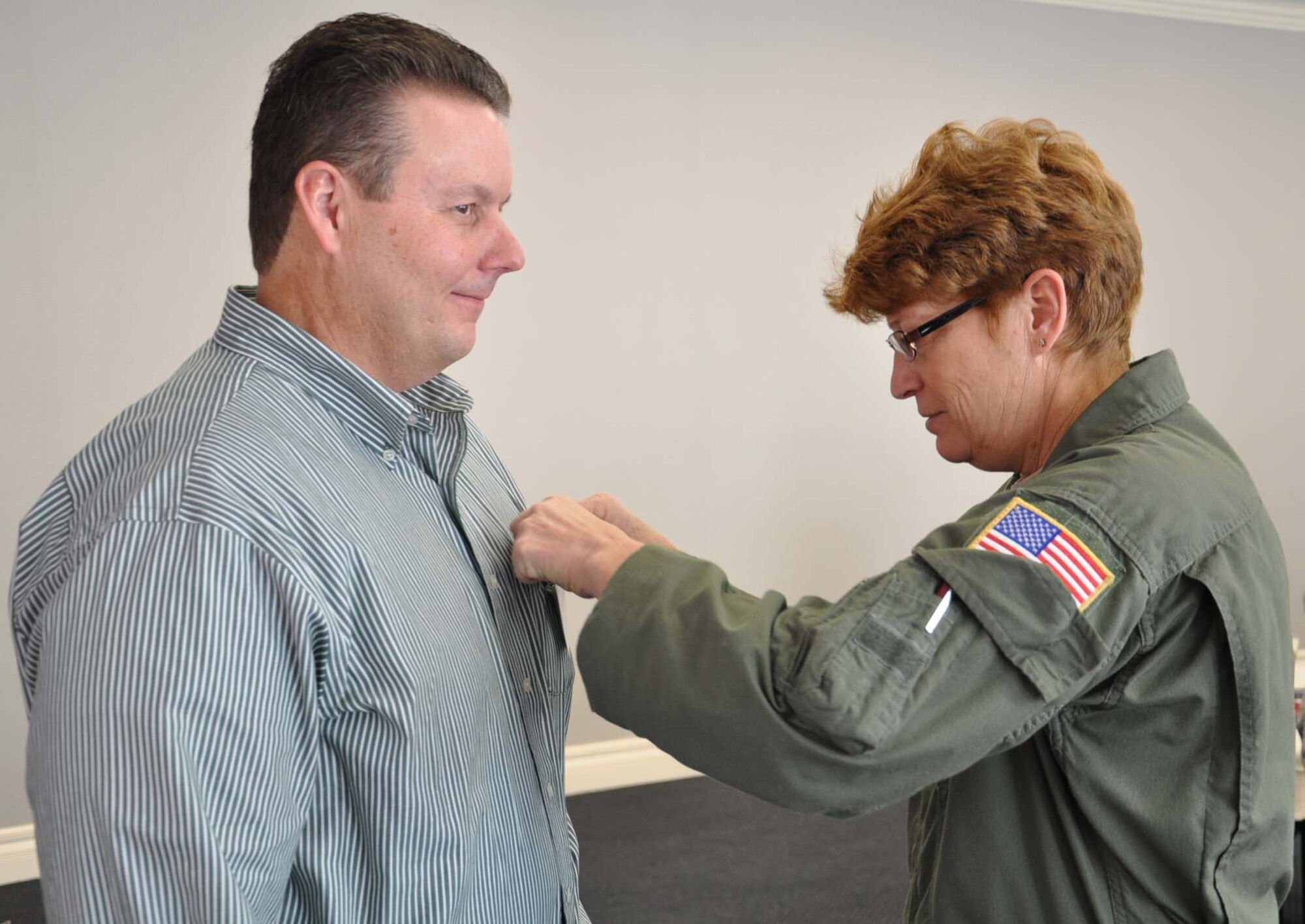 Chief Master Sgt. Kathy Lowman presents a commander's insignia pen to Ty Lasher, city manager of Bel Aire, Kan., and honorary commander to the 931st senior enlisted leader, during an honorary commander's luncheon in downtown Wichita, Kan., Nov. 5, 2011.  Chief Lowman presented the pin on behalf of Chief Master Sgt. Sean Martin.  Following the luncheon, honorary commanders were invited to visit the 931st headquarters at McConnell Air Force Base for a mission brief and to visit with 931st Airmen.  The purpose of the honorary commander program is to develop strong ties between the leaders of the 931st and the leaders of local communities.  (U.S. Air Force photo by Tech. Sgt. Brannen Parrish)