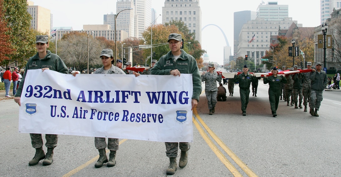 From left, Capt. Ruth Turner, Senior Airman Jessica Davila-Caba and Capt. Kevin Lovette display the 932nd Airlift Wing banner during the 28th annual St. Louis Veterans Day Parade on Nov. 5. Just behind were more than 25 wing members carrying a giant U.S. flag.  (U.S. Air Force photo/ Tech. Sgt. Christopher Parr)