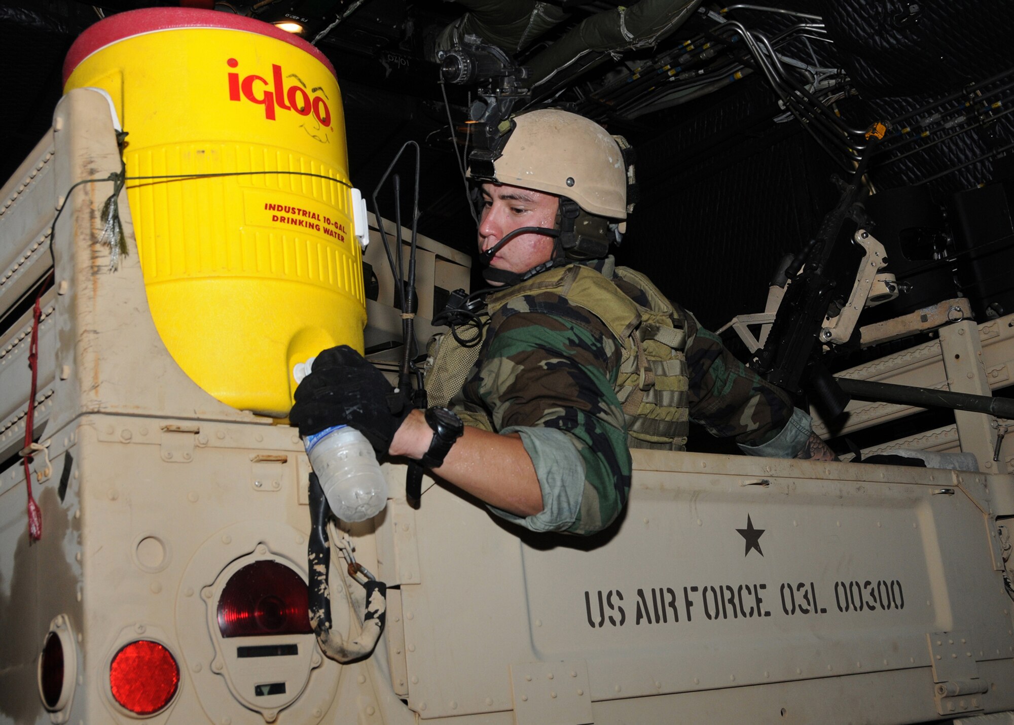 A student with the 23rd Special Tactics Training Squadron, tries to stay hydrated while sitting in a Humvee inside a MC-130E Combat Talon during a recent jump mission part of a two-day exercise at Duke Field, Fla.  The aircrew of reservists delivered approximately six Hurlburt Field Airmen and their equipment to their coordinates to begin the exercise.  The exercise provided counter-insurgency tactics, land navigation and mission planning to potential Air Force combat controllers.  (U.S. Air Force photo/Tech. Sgt. Cheryl Foster)