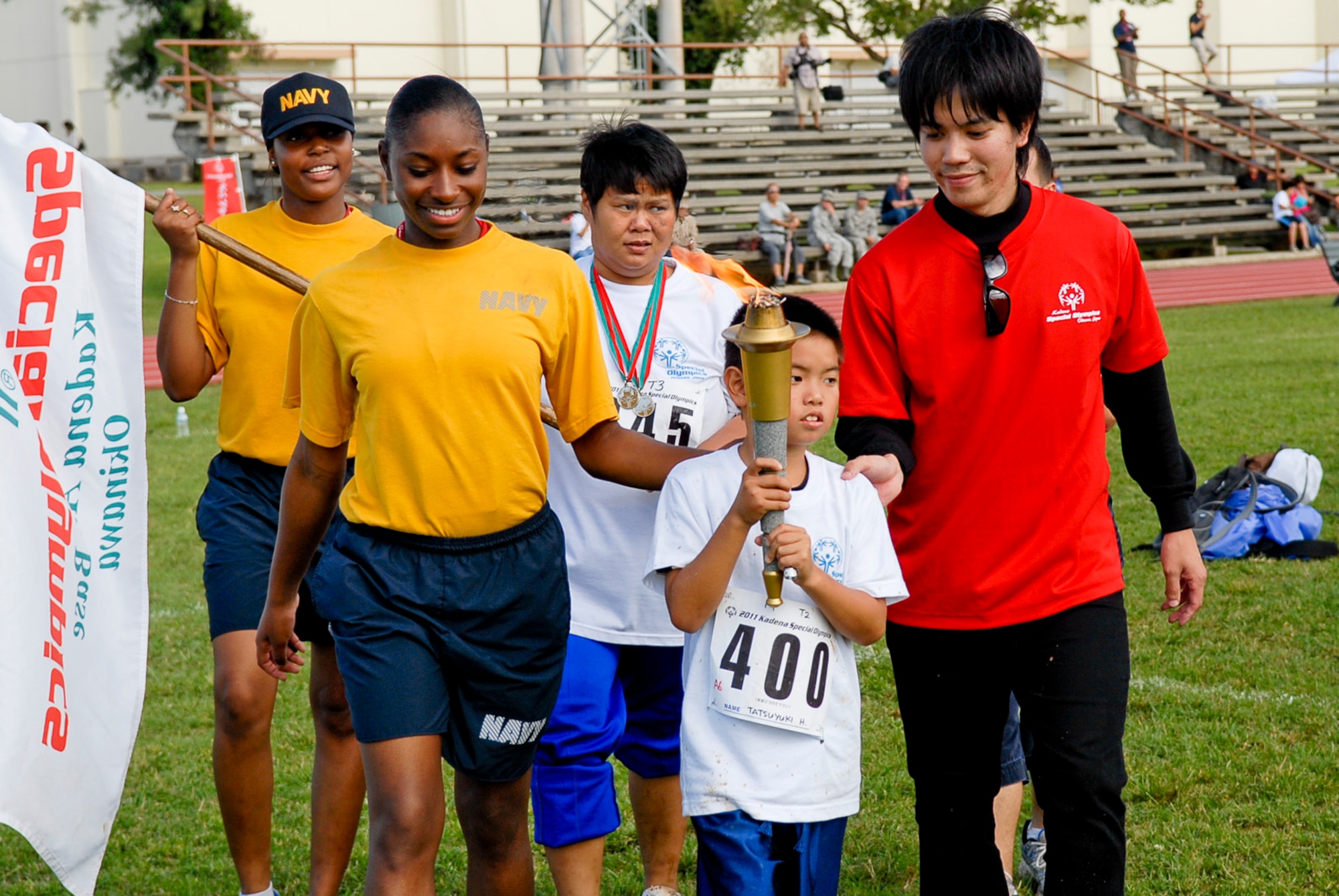 Selected athletes and huggers take a lap around the Circle of Friendship during the ending ceremony of the 12th Annual Kadena Special Olympics at Kadena Air Base, Japan, Nov. 5. Thousands of spectators and regional leaders from Japan and the United States came out to show support for more than 870 athletes and artists participating in the 12th Annual KSO Games and Art Show. (U.S. Air Force photo/Airman 1st Class Tara A. Williamson/released)