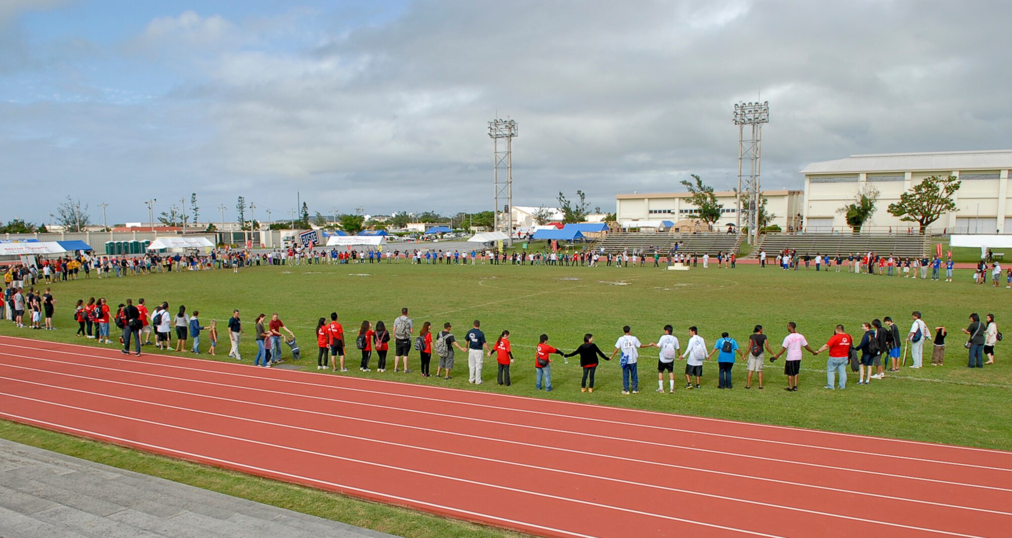 Special-needs athletes, American volunteers and local national interpreters, along with senior officials from the Government of Japan, Okinawa Prefectural Government, local communities and U.S. military members join in the Circle of Friendship as the ending ceremony of the 12th Annual Kadena Special Olympics begins at Kadena Air Base, Japan, Nov. 5. KSO began in 2000 with approximately 400 athletes and 600 volunteers as an 18th Wing community goodwill initiative to strengthen U.S. - Okinawa relationships. Eleven years later, the event has doubled in size and participation. (U.S. Air Force photo/Airman 1st Class Tara A. Williamson/released)