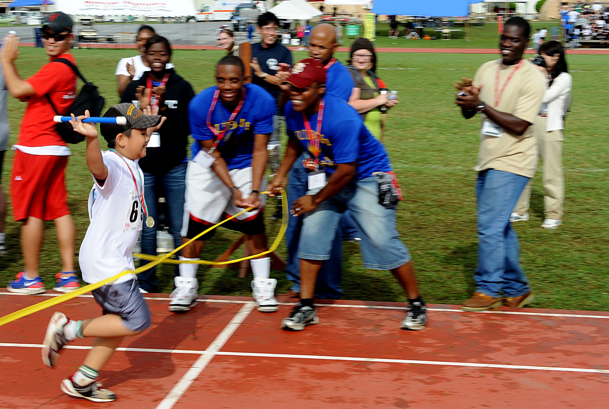 A Kadena Special Olympics athlete crosses the finish line after completing a 400 yard relay race, Kadena Air base, Japan, Nov. 5. KSO began in 2000 with approximately 400 athletes and 600 volunteers as an 18th Wing community goodwill initiative to strengthen U.S. - Okinawa relationships. (U.S. Air Force photo/A1C Justin Veazie/released)