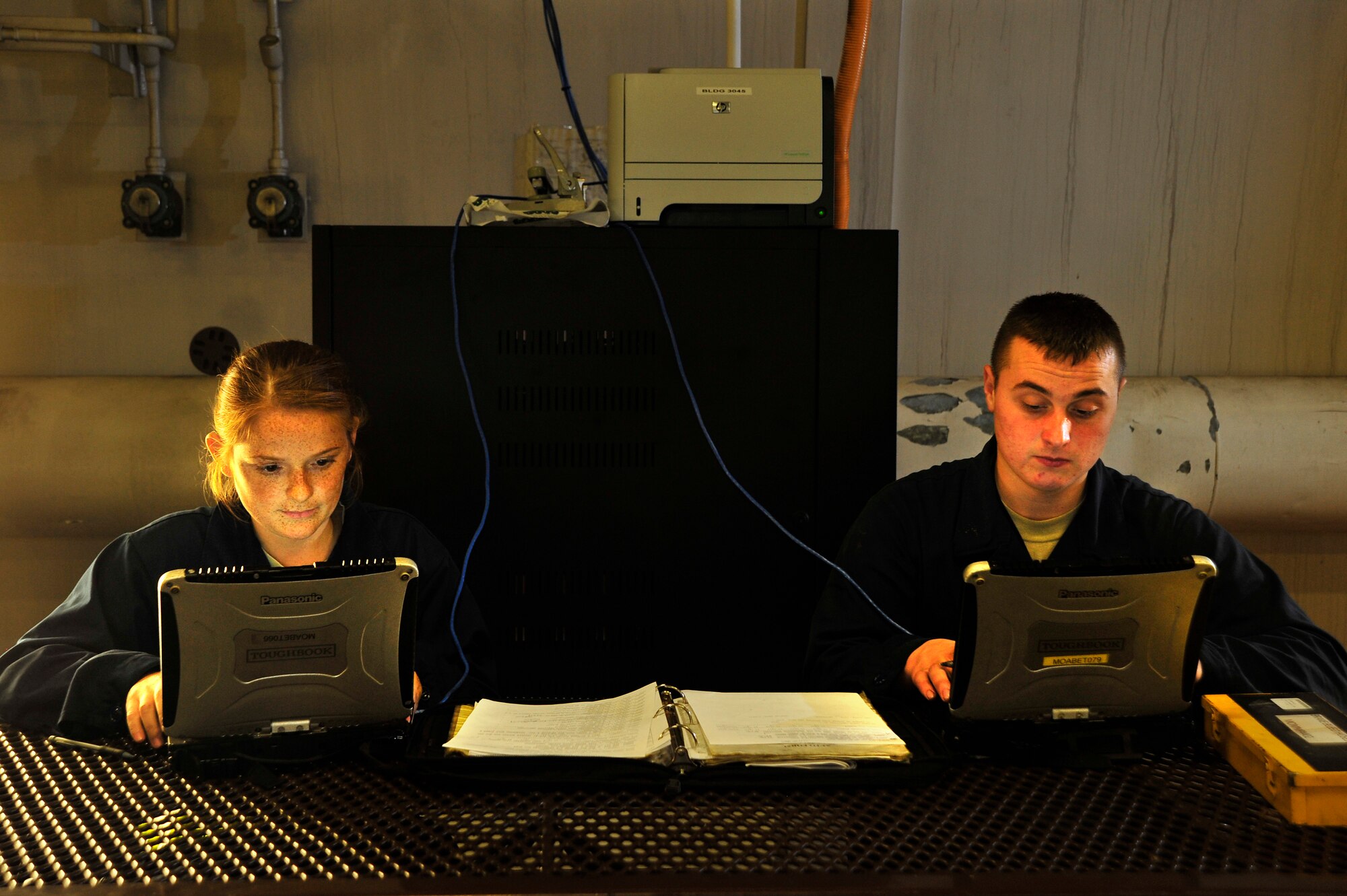 MISAWA AIR BASE, Japan - U.S. Air Force Staff Sgt. Melody Weisbaum, left, and Airman 1st Class Robert Wickman, 14th Aircraft Maintenance Unit, input maintenance reports to the integrated maintenance data system from a hardened aircraft shelter during an operational readiness exercise here Nov. 5. The 35th Maintenance Squadron is testing the new internet capability in its HAS’s for the first time as part of the exercise. (U.S. Air Force photo/Staff Sgt. Nathan Lipscomb)      
