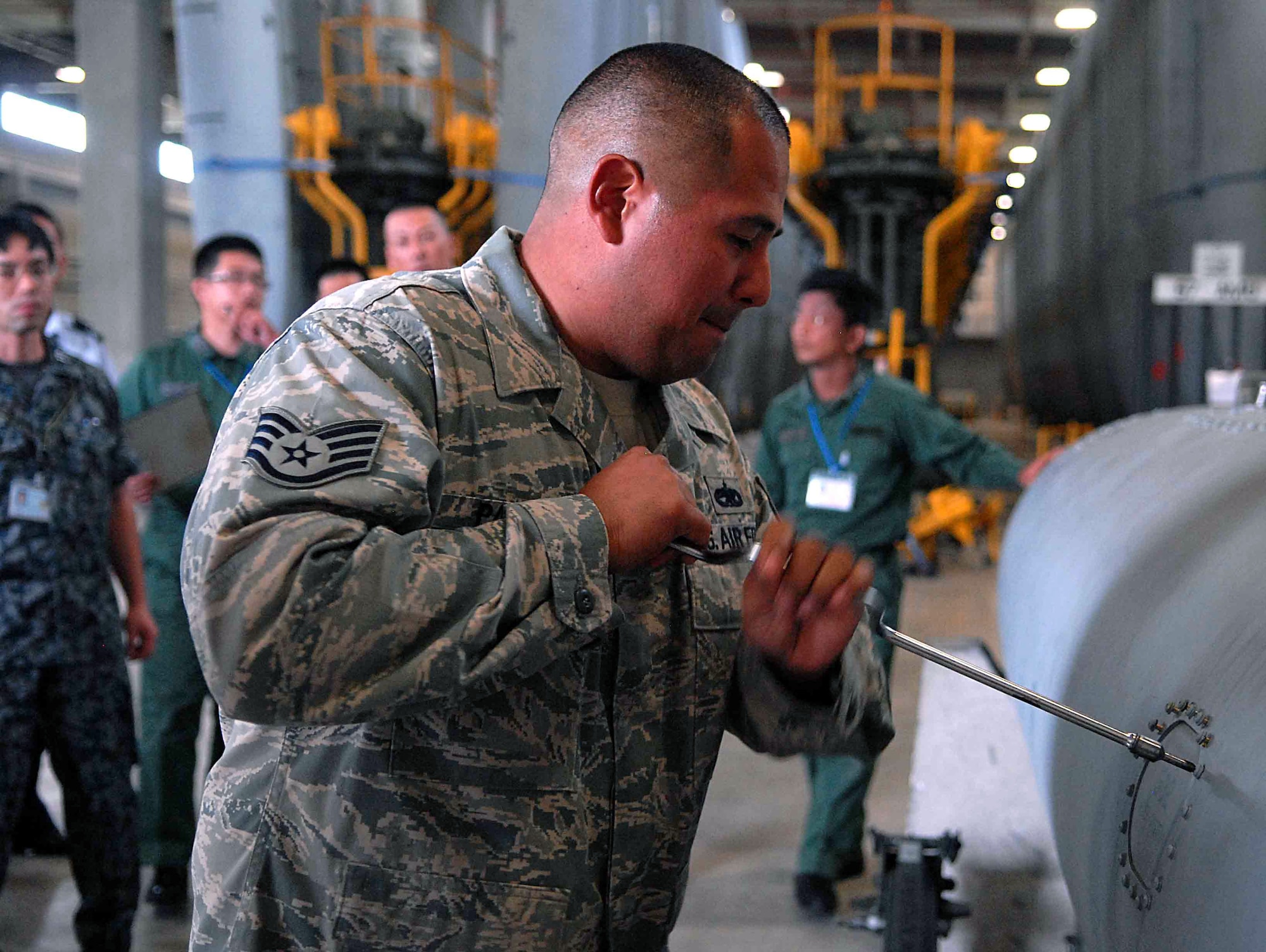 U.S. Air Force Staff Sgt. Gilbert Palos, 18th Component Maintenance Squadron fuels system craftsman and squadron ?superstar?, walks members of the Japan Air Self Defense Force maintenance division through an annual inspection of an F-15C external fuel tank Oct. 31 at Kadena Air Base, Japan. Members of the JASDF located in Naha, Japan and the Air Defense Command maintenance branch chief in Tokyo, Japan visited the 18th Maintenance Group to learn different processes and techniques on how to better maintain their own F-15Cs. ?We are showing our JASDF visitors how we perform maintenance inspections and treatment of the external fuel tanks when removed from the aircraft,? said Capt. Jhames B. Illanez, 18th Component Maintenance Squadron operations officer. ?Having a good working relationship between the U.S. and the JASDF further increases our capability and interoperability.? (U.S. Air Force photo/Senior Airman Sara Csurilla)  